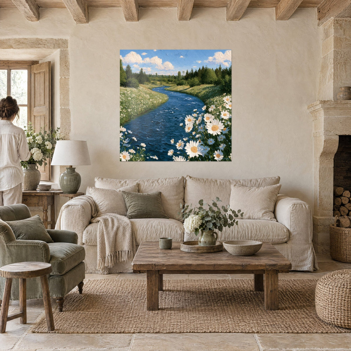Wall art of a cobalt blue river winding through flowering meadows, white daisies, a person seen from behind, above a sofa in a bright living room