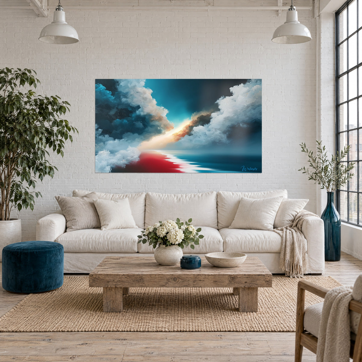 Quadro cielo in tempesta squarciato da un varco dorato di luce, nuvole blu petrolio e bianche, riva rossa, sopra un divano in un soggiorno luminoso