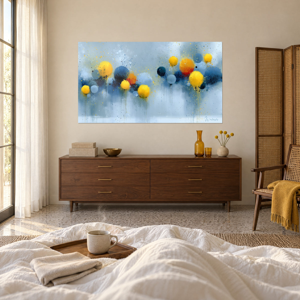 Tableau ballons abstraits jaune vif et bleu ciel aux éclaboussures dorées, au-dessus d'un lit dans une chambre claire