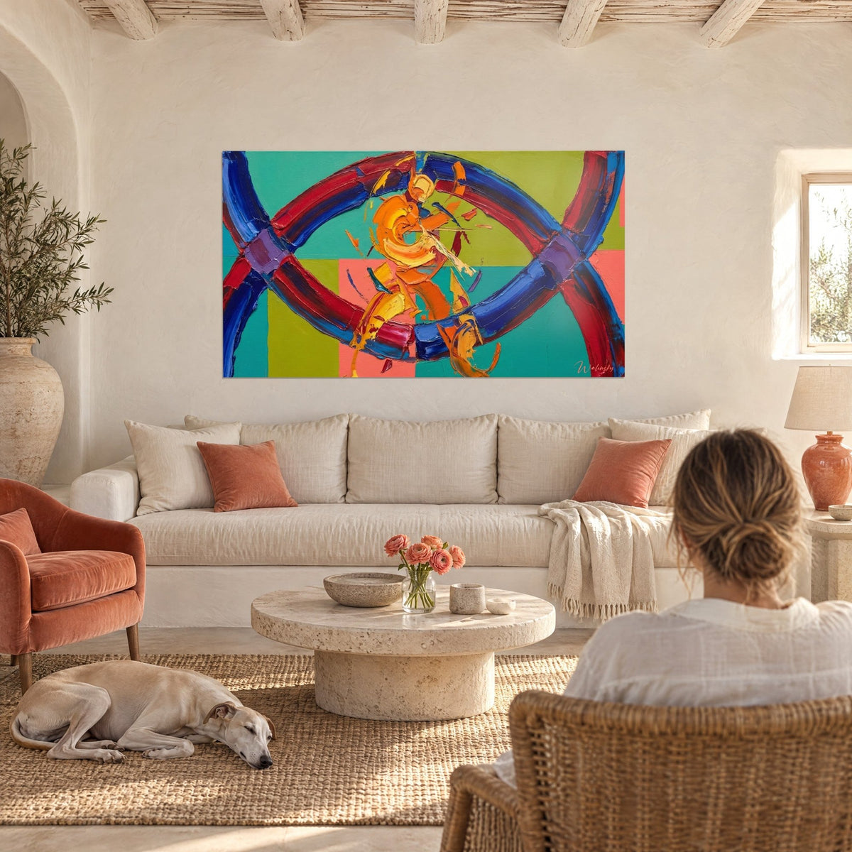 Schilderij met in elkaar grijpende blauwe en rode ringen, met een spatel geschilderd op een turquoise en appelgroen dambordpatroon, boven een bank in een lichte woonkamer