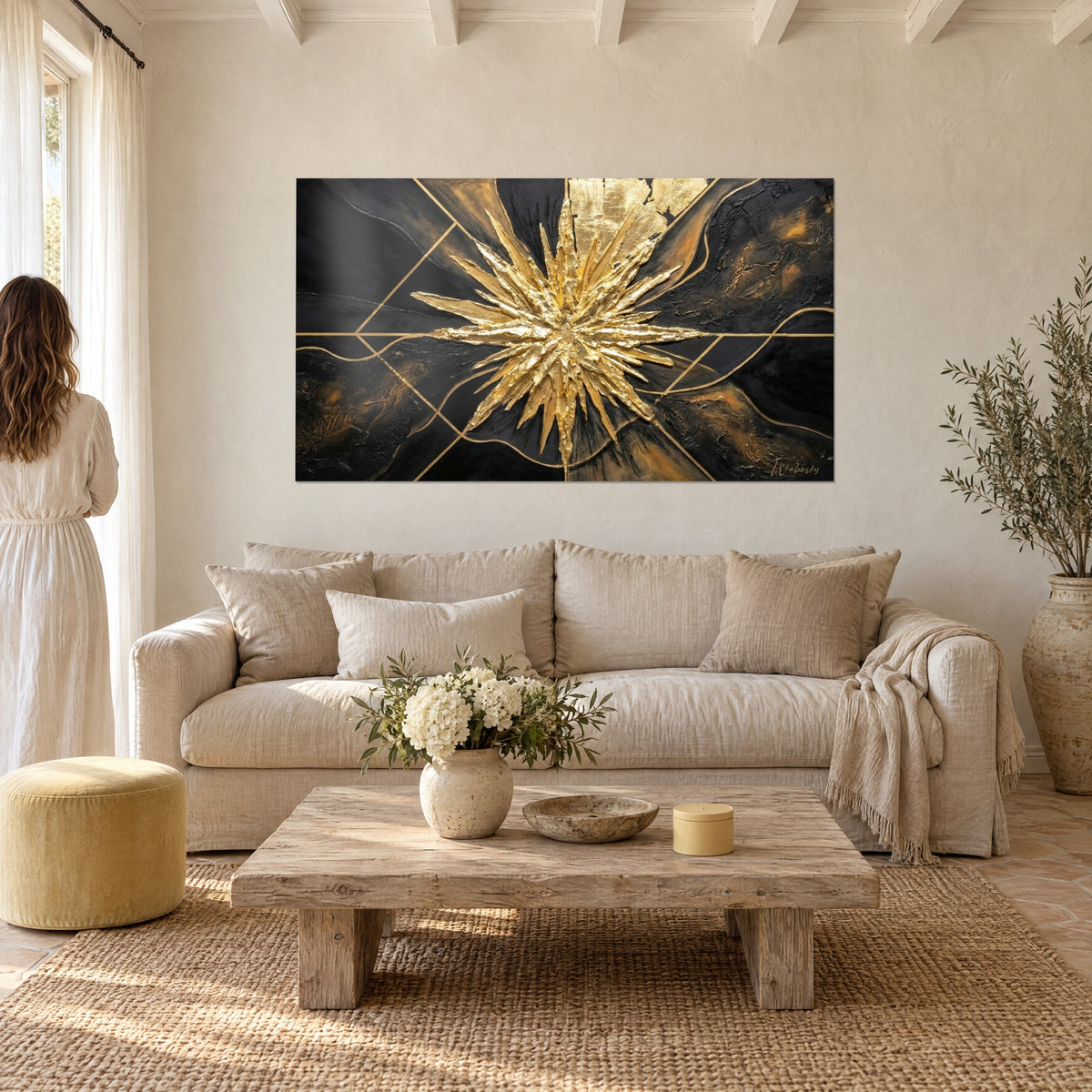 Gemälde mit goldenem Stern in Relief auf anthrazitfarbenem Grund, kupferfarbene Linien, über einem Sofa in einem hellen Wohnzimmer