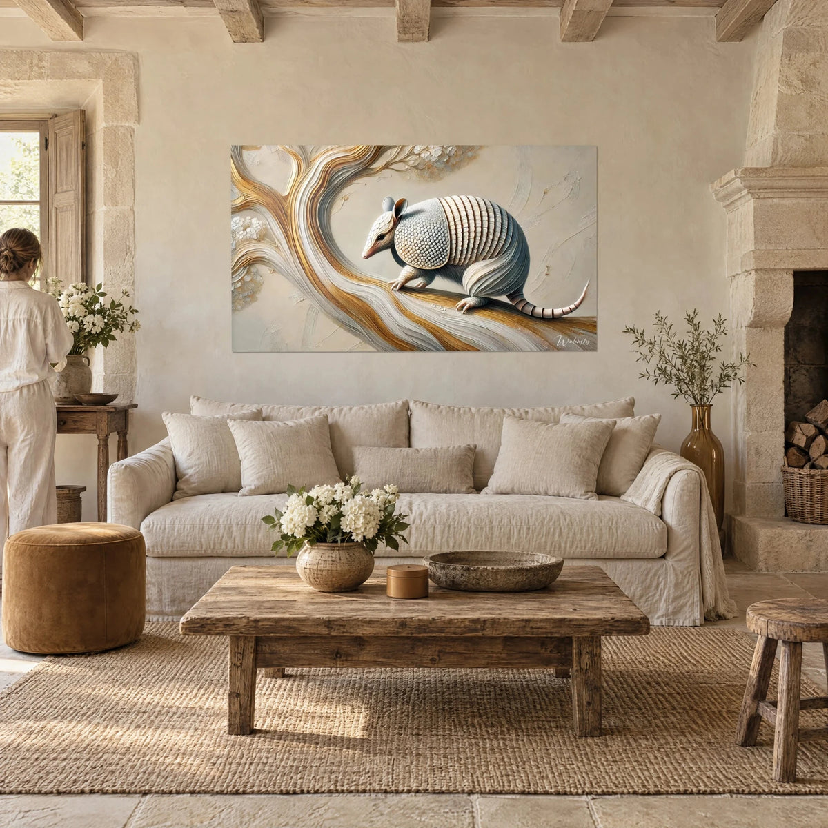 Wall art of an armadillo with mother-of-pearl plates on a gold and ivory branch, person seen from behind, above a sofa in a bright living room