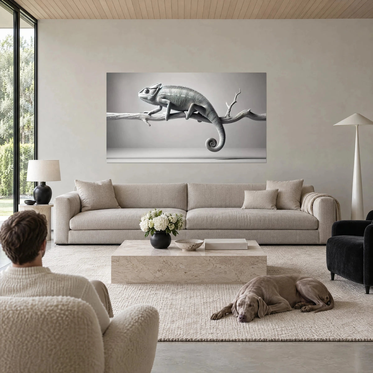 Gemälde Chamäleon in Grau auf einem weißen Ast sitzend, spiralförmiger Schwanz, über einem Sofa in einem hellen Wohnzimmer