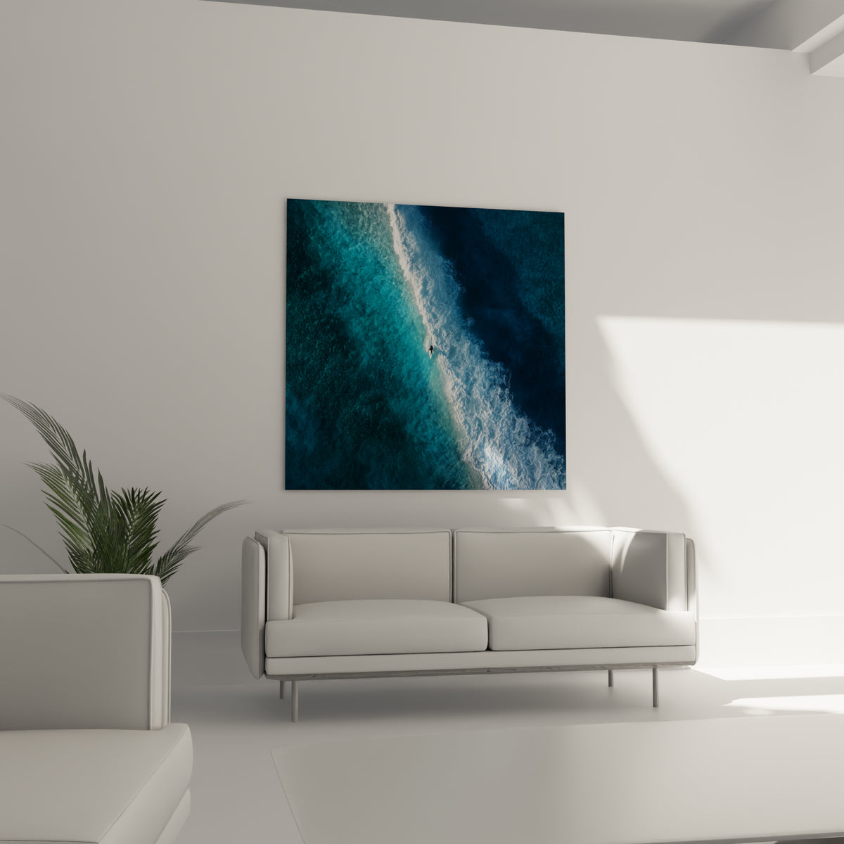 Vague déferlante turquoise et anthracite avec surfeur minuscule, au-dessus d'un canapé dans un salon lumineux