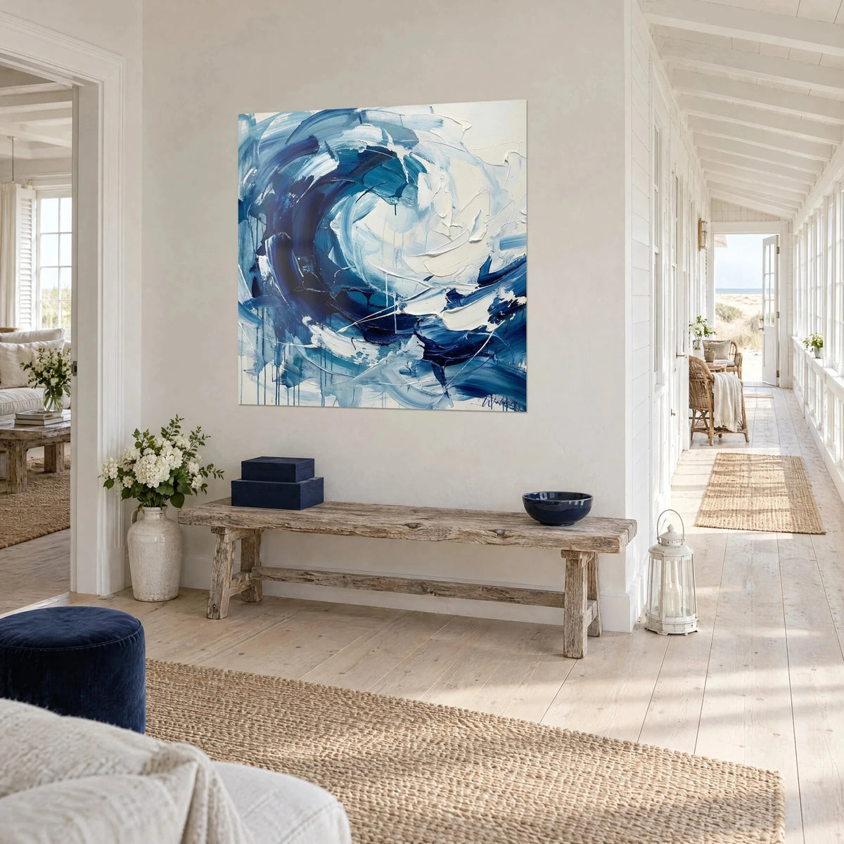 Schilderij van een oceaanwervel in koningsblauw en schuimwit, verticale druipsporen onderaan, witte muur van een strandhuis