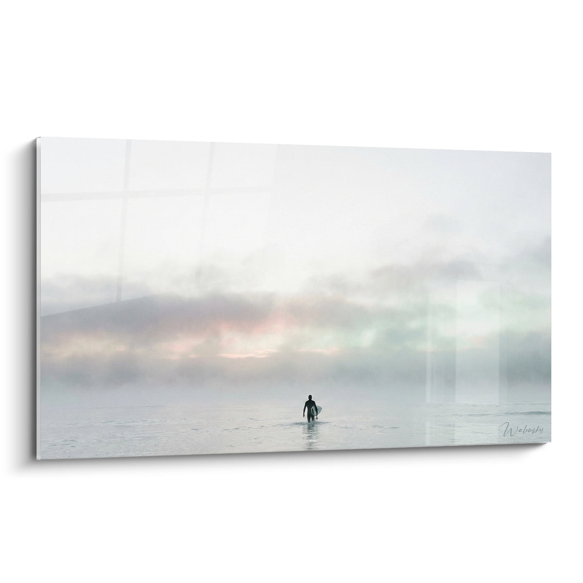 Surfeur silhouette noire avançant dans une brume grise et rose vers l'océan