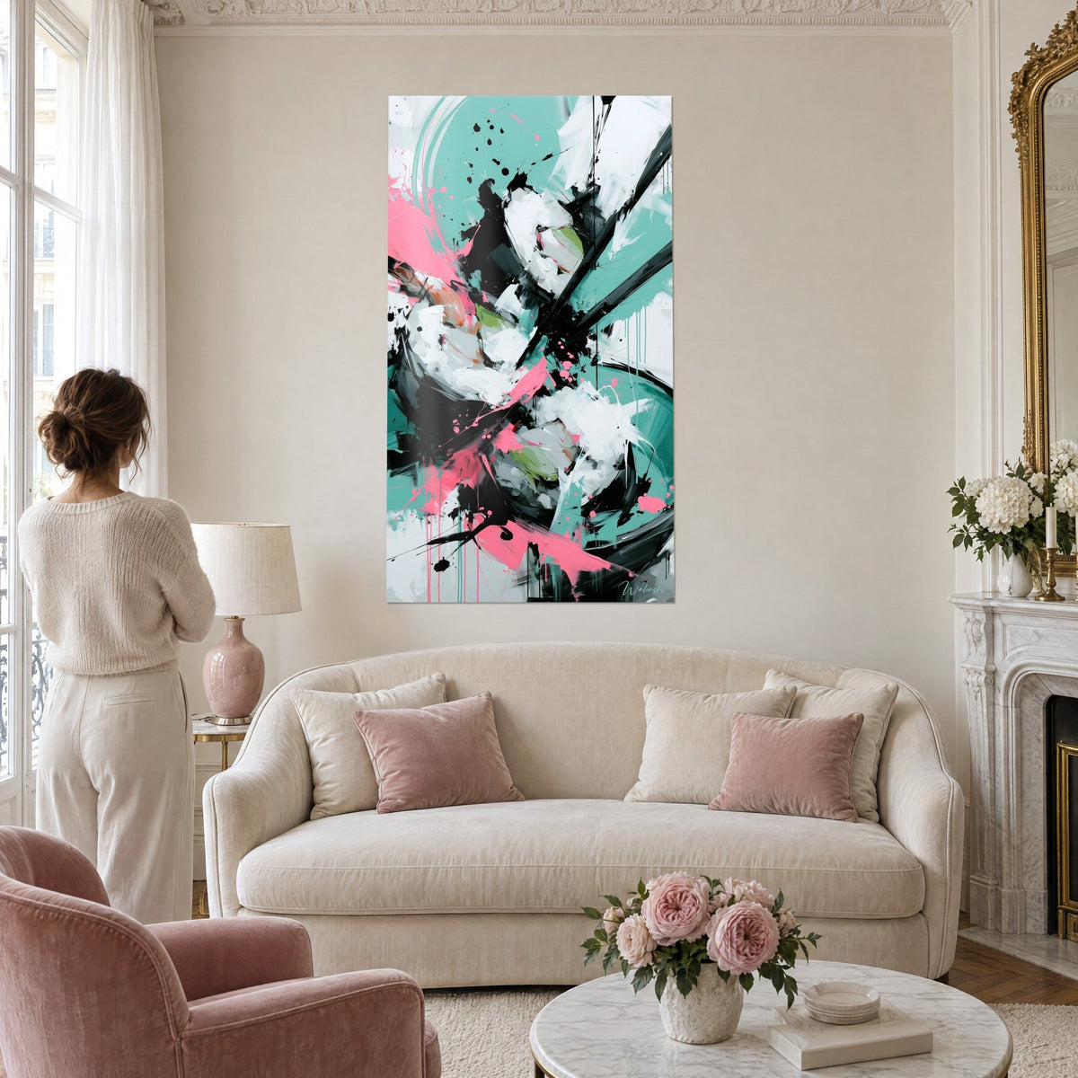 Wall art abstract maki with black splashes on a turquoise background, pink touches, woman seen from behind, above a sofa in a bright living room
