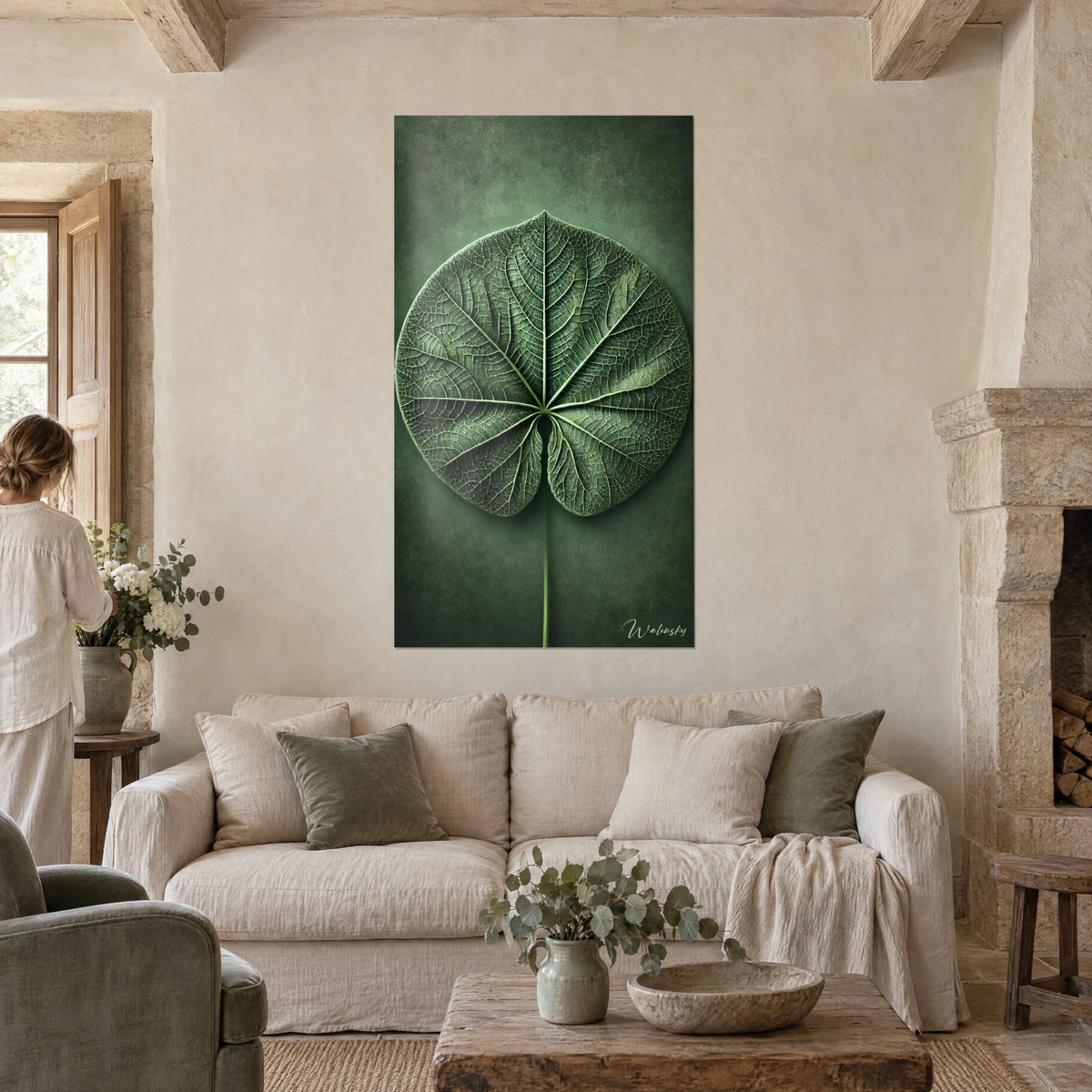 Cuadro de una hoja redonda con nervaduras finamente grabadas, verde salvia y verde bosque, sobre un sofá en un salón luminoso