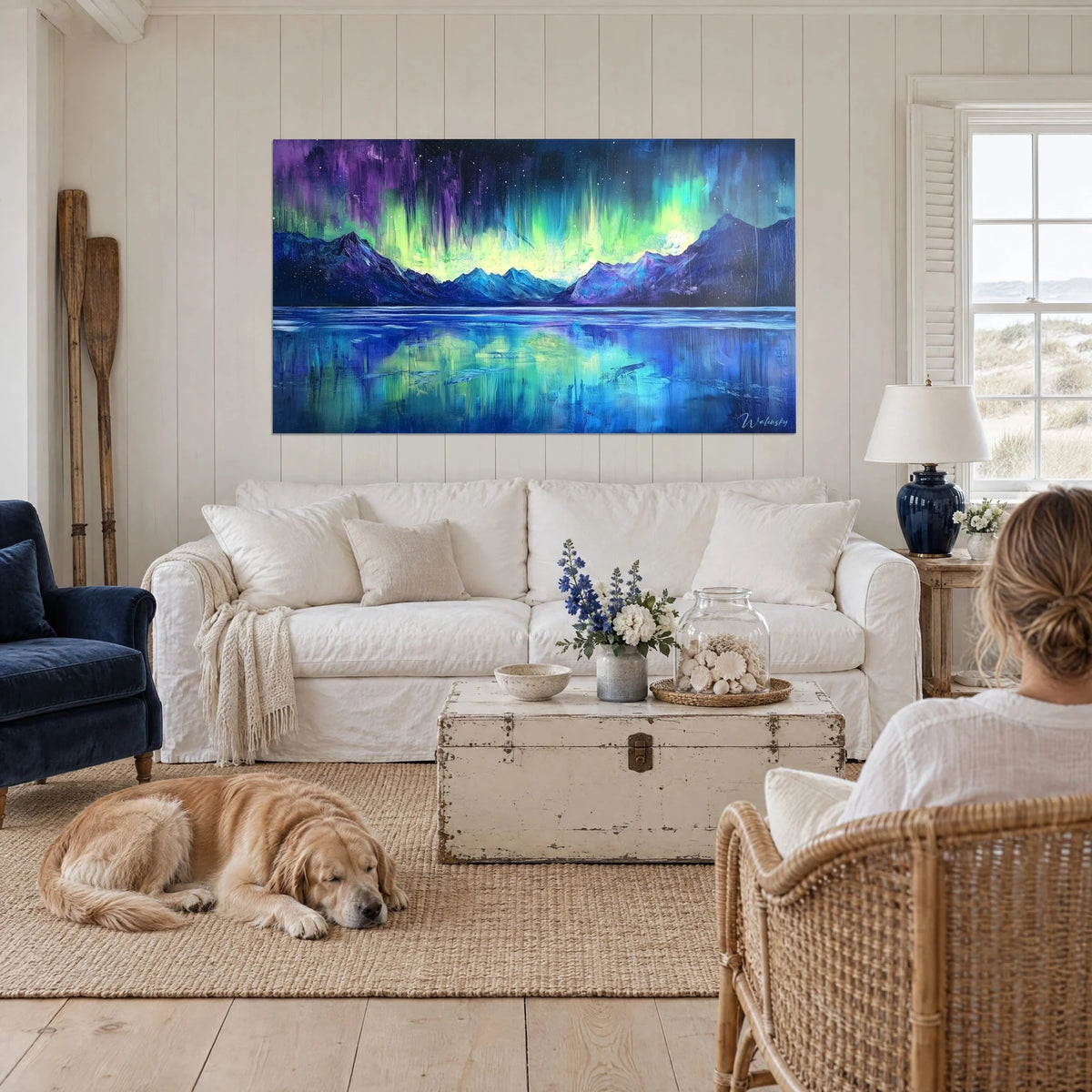 Tableau aurore boréale verte sur lac gelé bleu, un retriever couché dessous, au-dessus d'un canapé dans un salon lumineux