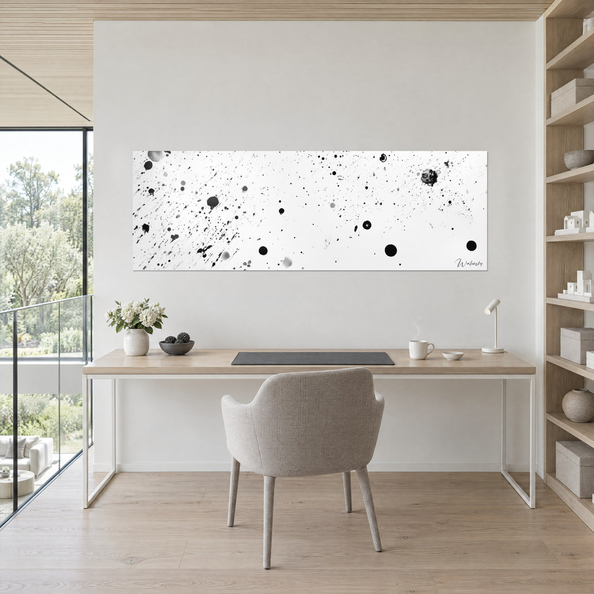Gemälde mit schwarzen Tintenspritzern und grauen Pünktchen auf strahlendem Weiß, Schreibtisch aus hellem Holz, graues Stuhl, offene Regale