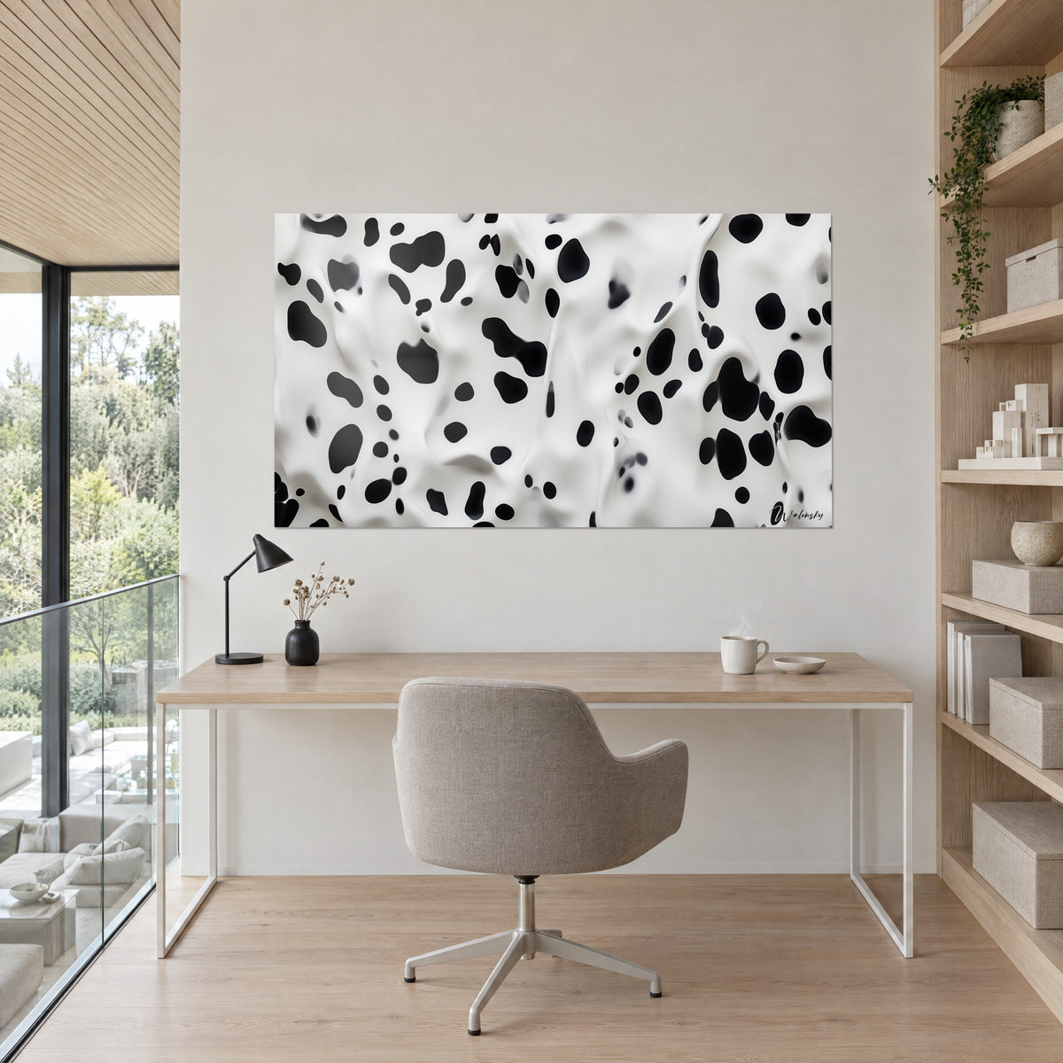 Tableau constellation de pois noirs sur fond blanc nacré, accroché au-dessus d'un bureau en chêne clair et d'un fauteuil gris dans un bureau lumineux