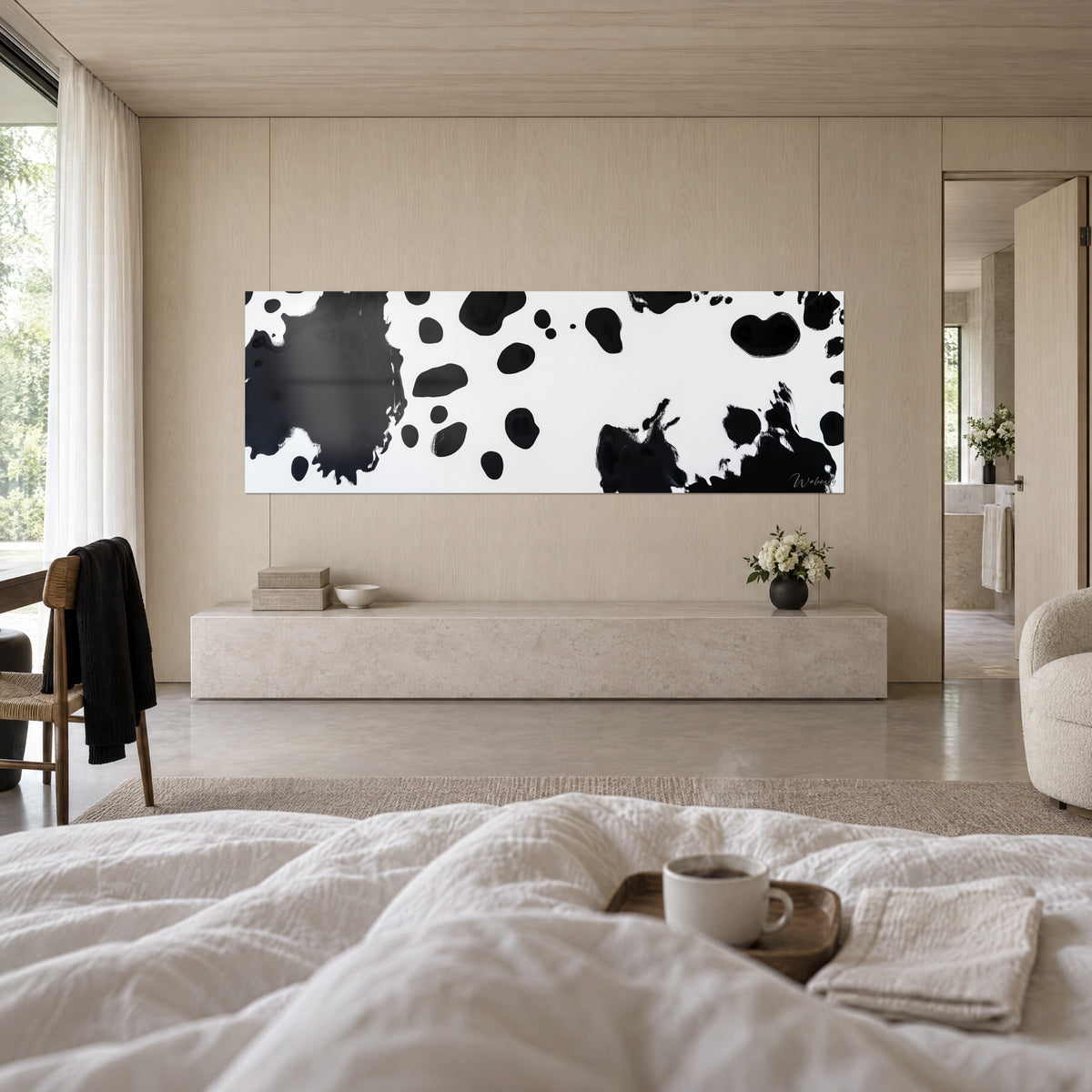 Schilderij met abstract dalmatiërpatroon, zwarte inktvlakken en crèmewit, boven een bed in een lichte slaapkamer