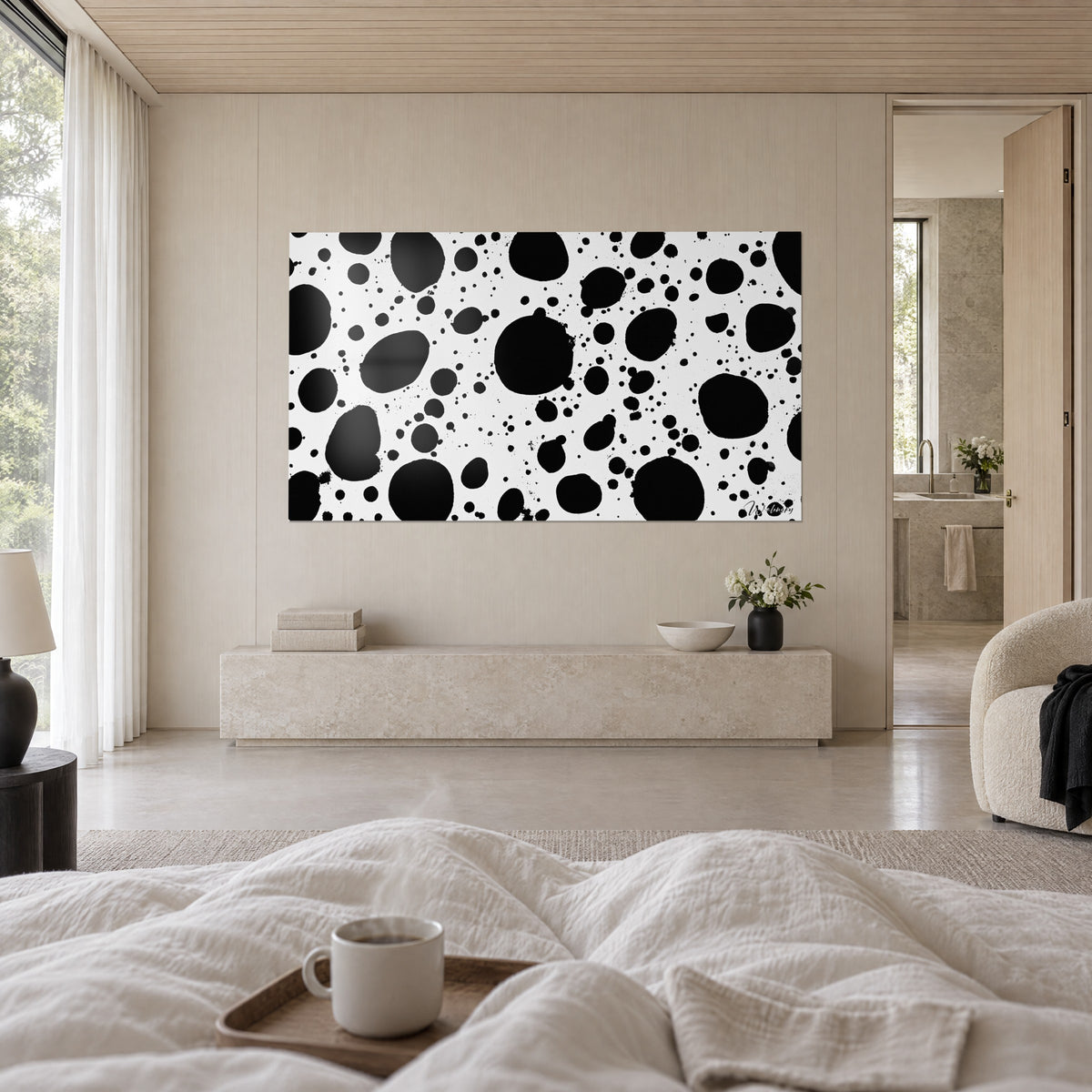 Wall art with irregular black dots on a bright white background, ink droplets like rain, above a bed in a light bedroom