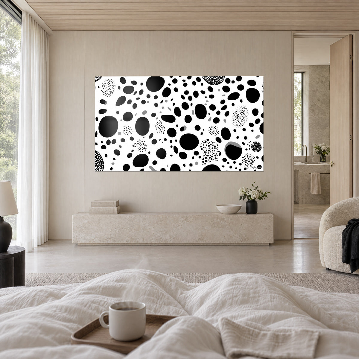 Wall art with irregular black circles on pure white, grey accents, above a bed in a bright bedroom