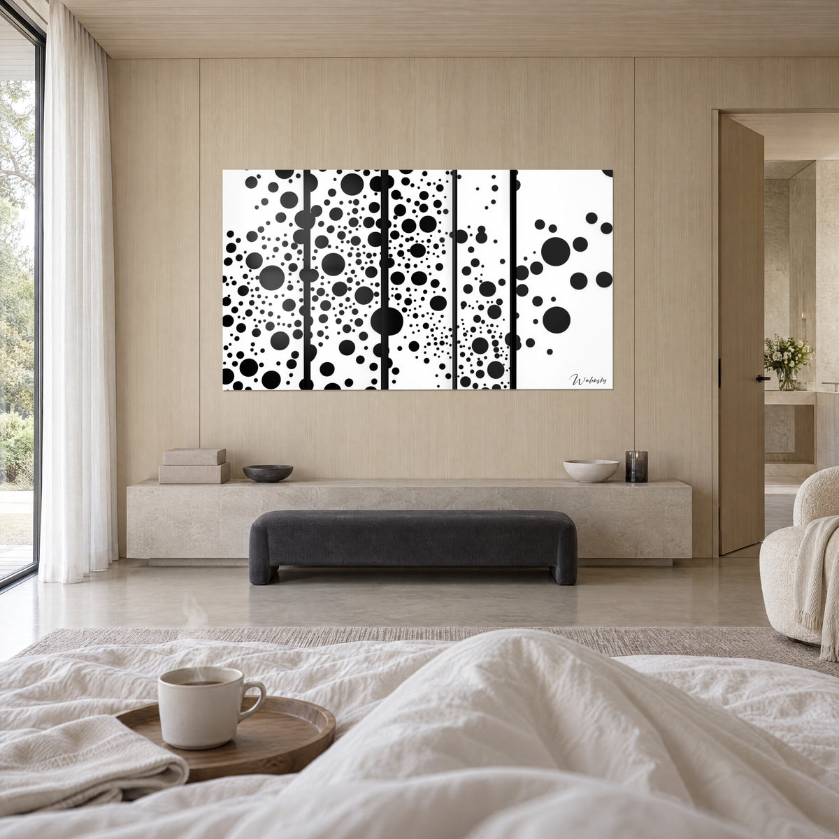 Tableau taches noires en pluie sur cinq lés blancs, couple de dos face au mur, plaid blanc au-dessus d'un lit dans une chambre claire