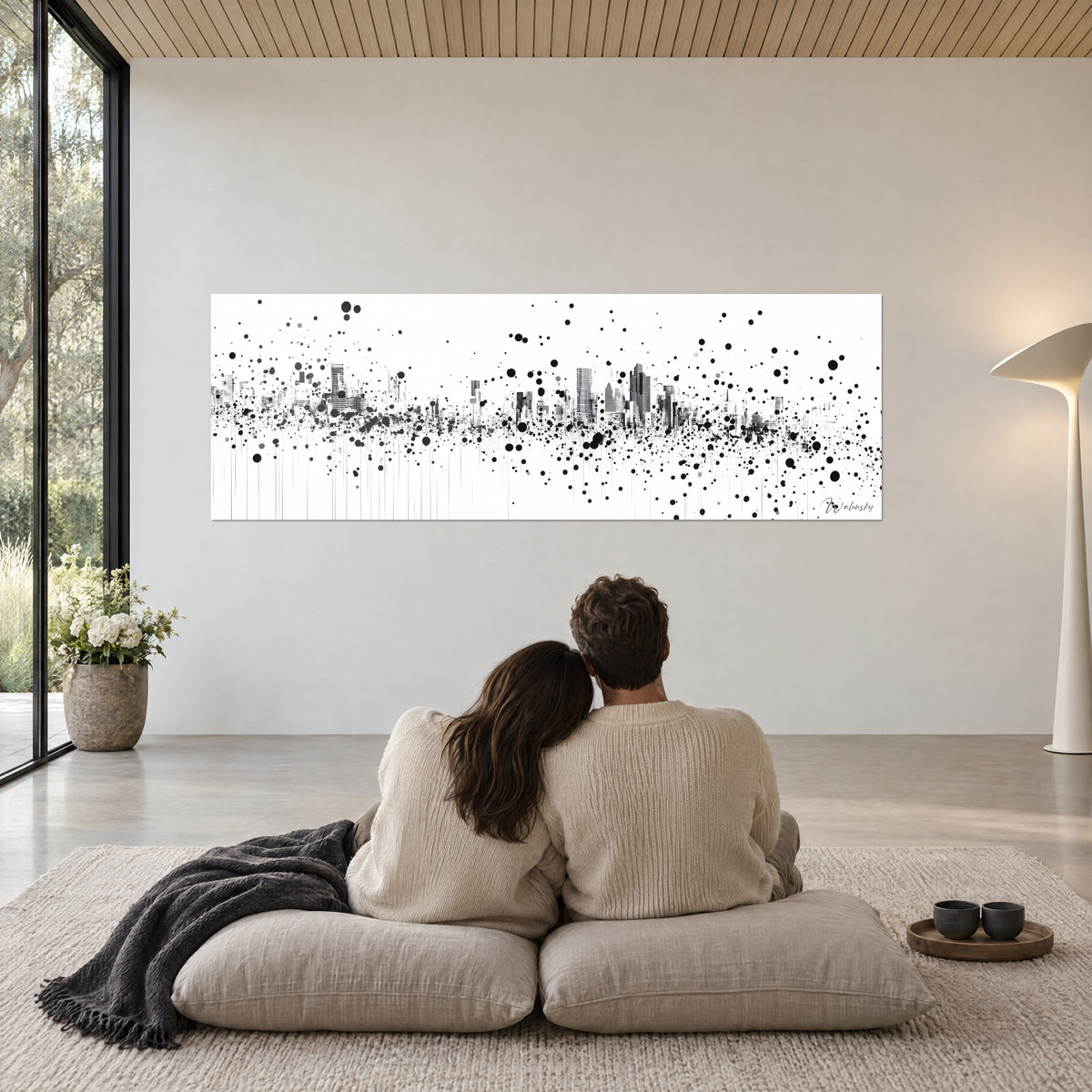 Gemälde einer urbanen Vision voller Spritzer, graue Wolkenkratzer und schwarze Flecken auf weißem Grund, Paar auf beigen Kissen mit Blick auf die Wand