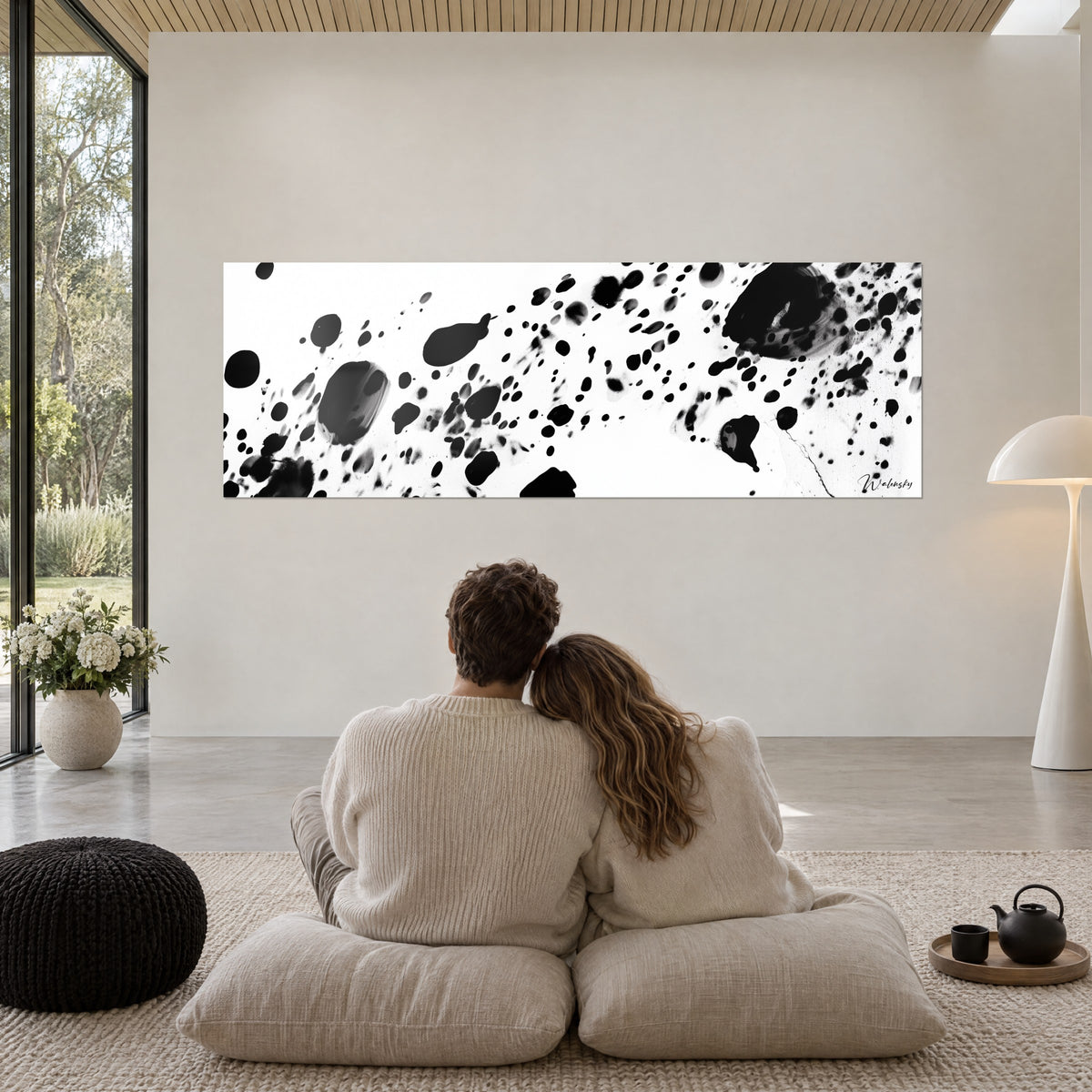 Quadro di costellazione di schegge di inchiostro nero su fondo bianco, grande massa scura a destra, parete grigio perla e vetrata