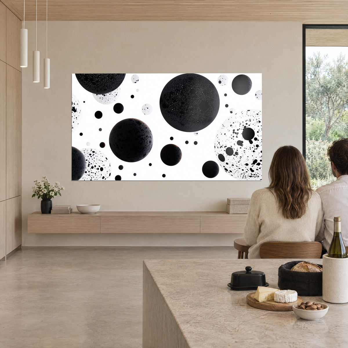 Quadro di una costellazione di sfere d'ebano e orbe color crema punteggiate di macchie, osservato di spalle da una coppia vicino a un'isola della cucina
