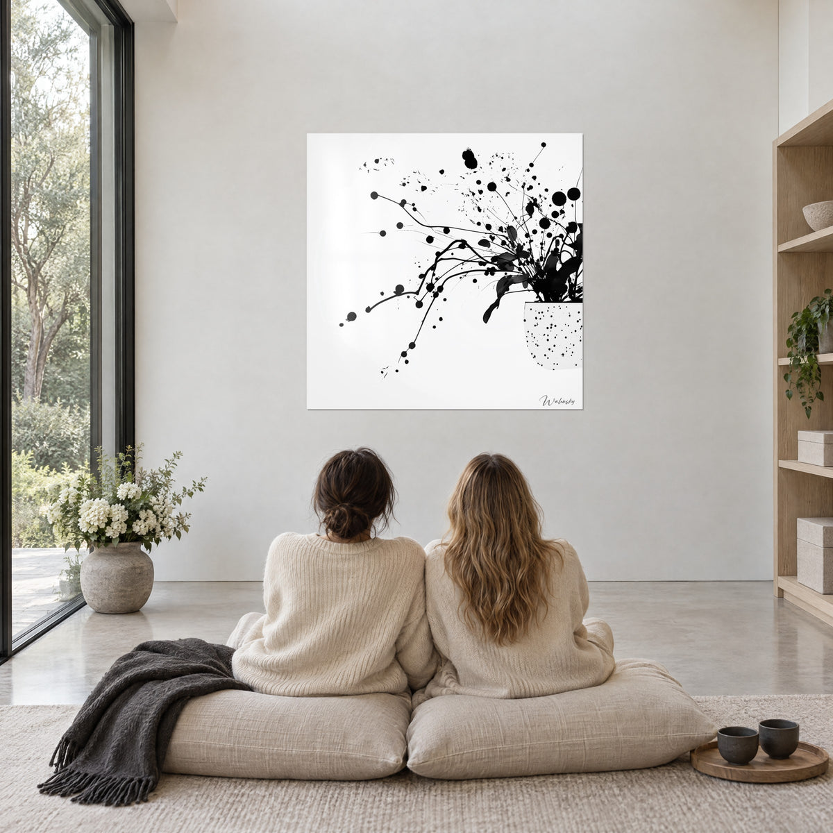 Schilderij gestileerde bloemen van zwarte inktspatten, witte pot met zwarte stippen, woonkamer met beige steen en blond hout