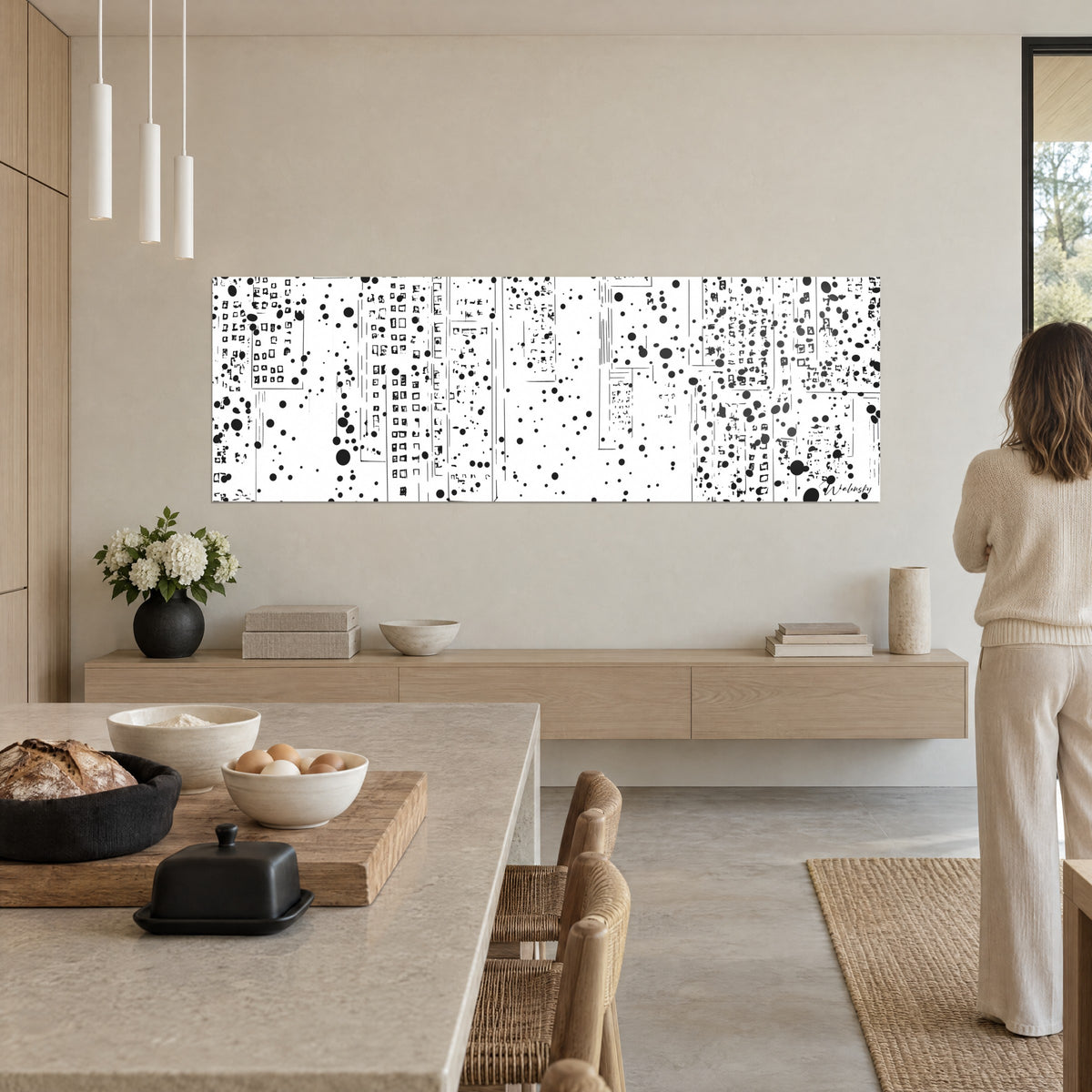 Gemälde Turmfassaden in schwarzen Linien und runden Spritzern auf Weiß, Frau von hinten, offene Küche, beige Wand