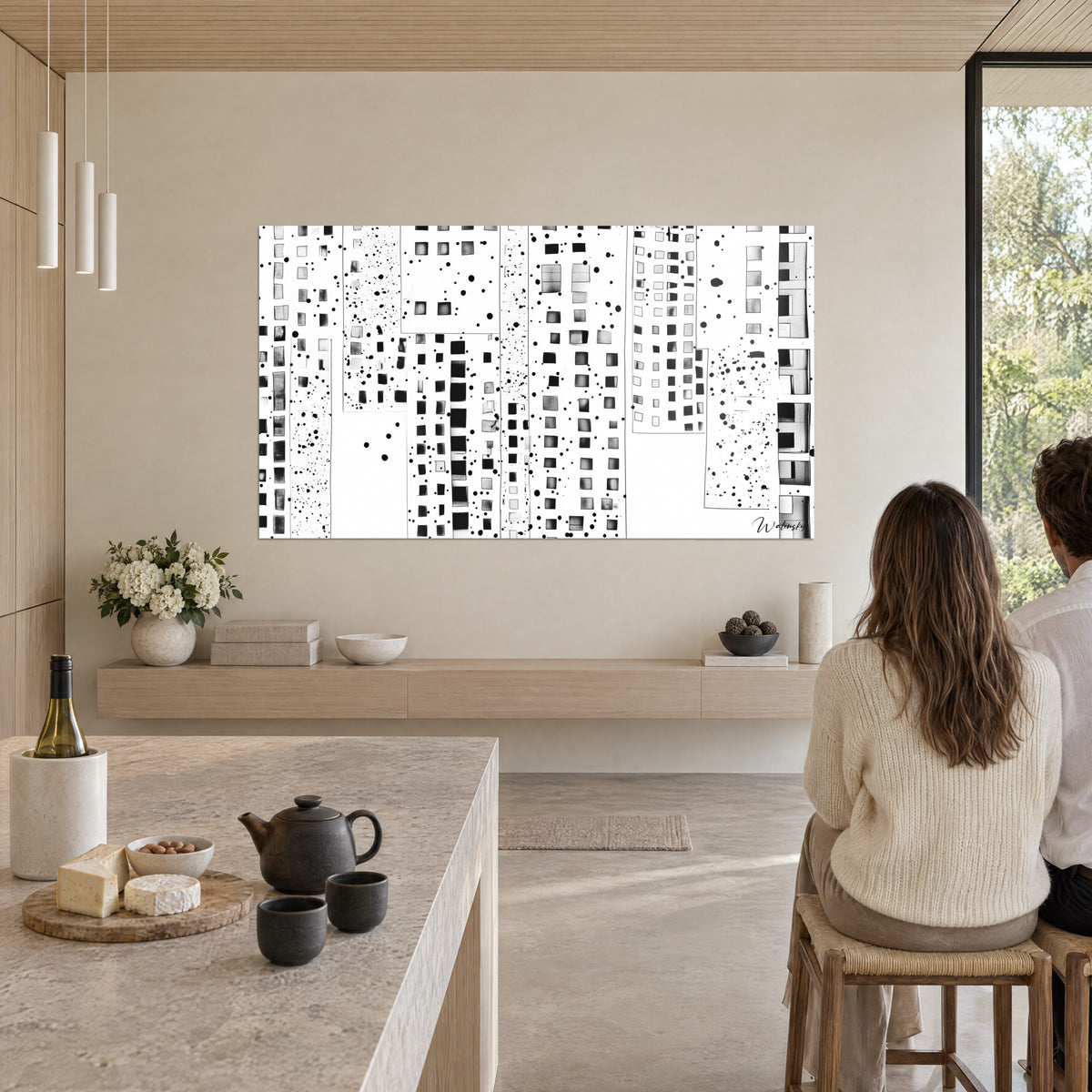 Schilderij van een gepixelde stad, grijze en zwarte vlakken met inktdruppeltjes, twee personen van achteren aan tafel in een open keuken