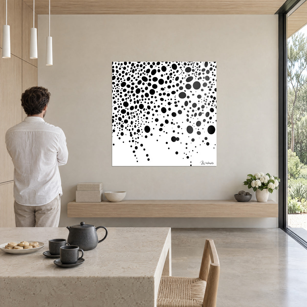 Tableau semis de gouttes noires et blanches, pois denses en haut à gauche, homme en chemise blanche de dos, étagère en chêne clair