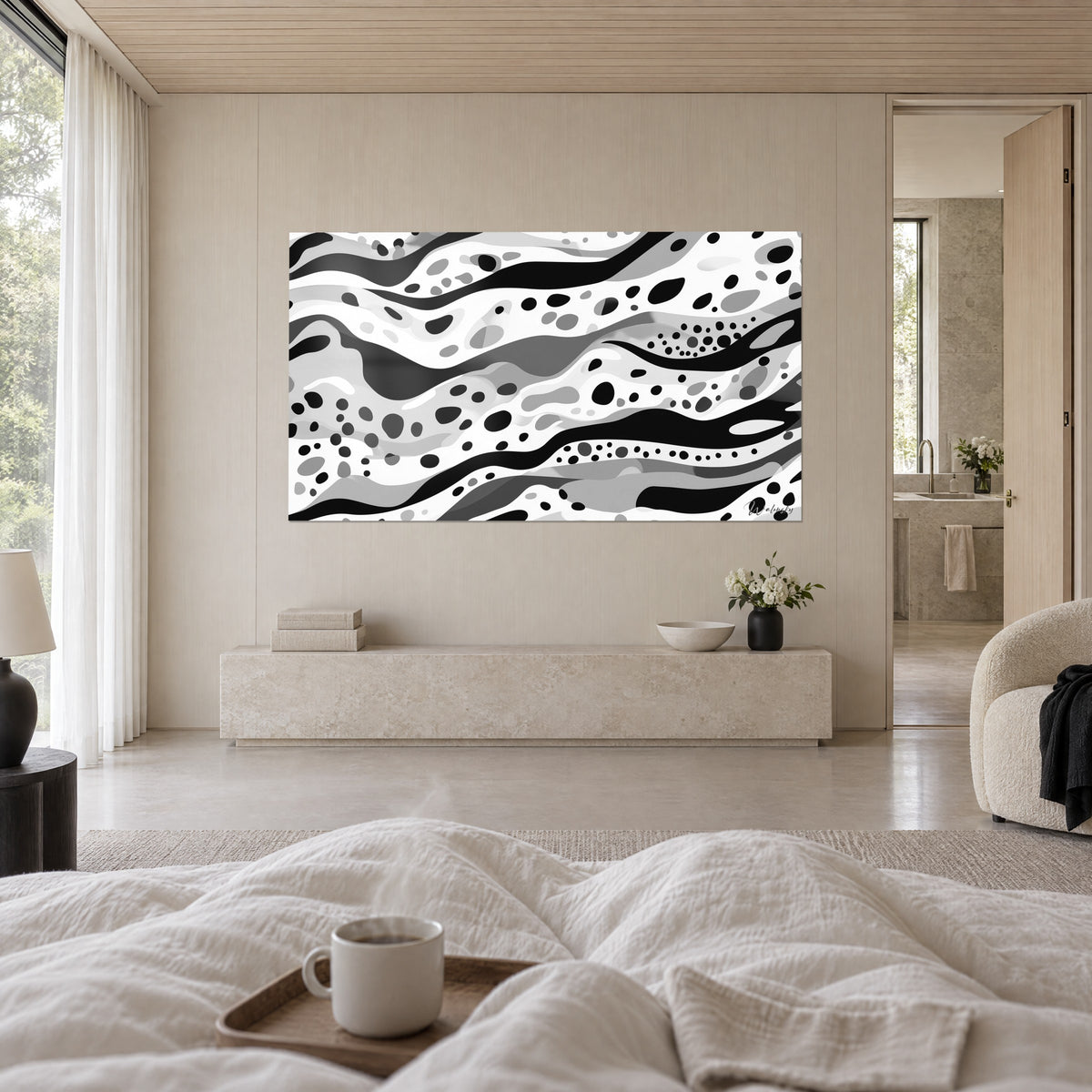 Cuadro abstracto de cintas negras, blancas y grises moteadas, frente a una cama con sábanas arrugadas, encima de una cama en un dormitorio luminoso