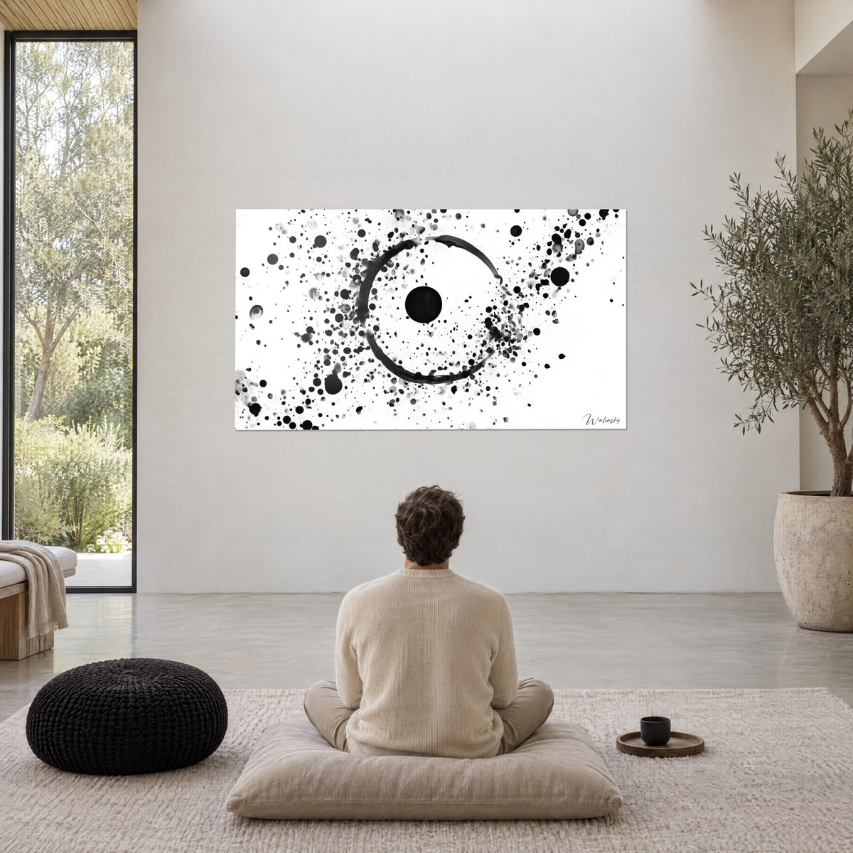 Gemälde Finsternis aus schwarzer Tinte, übersät mit grauen Tröpfchen auf weißem Grund, cremefarbene Wand eines Wohnraums, schwarzes Meditationskissen