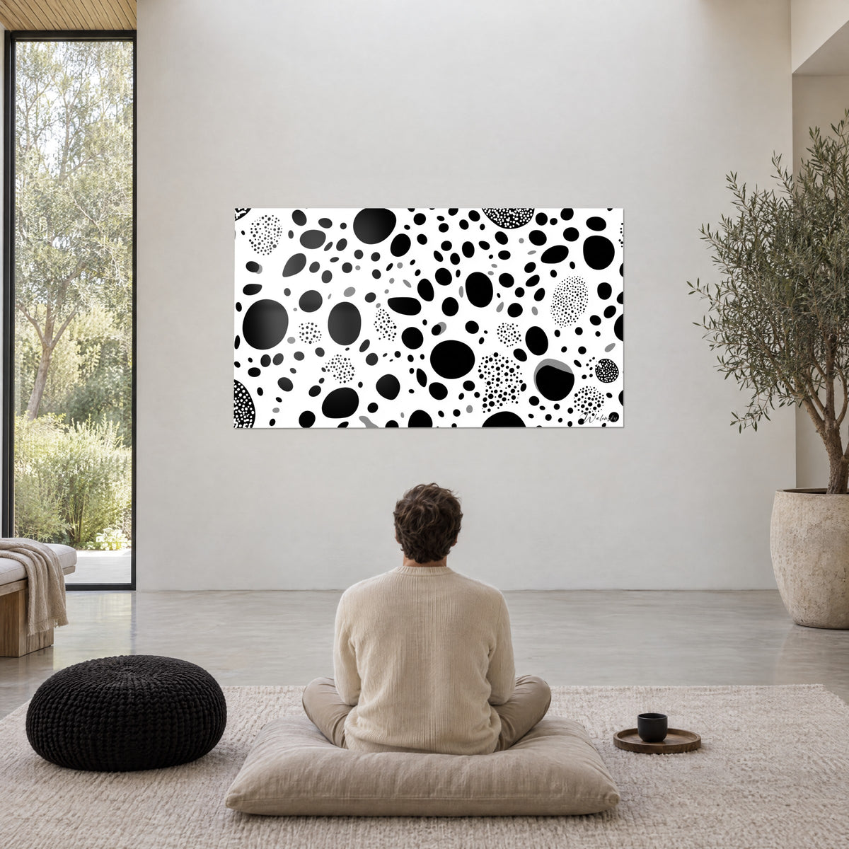Wall art with black and white spotted coat pattern, large ebony ovals and fine dots, white wall of a living room with large windows