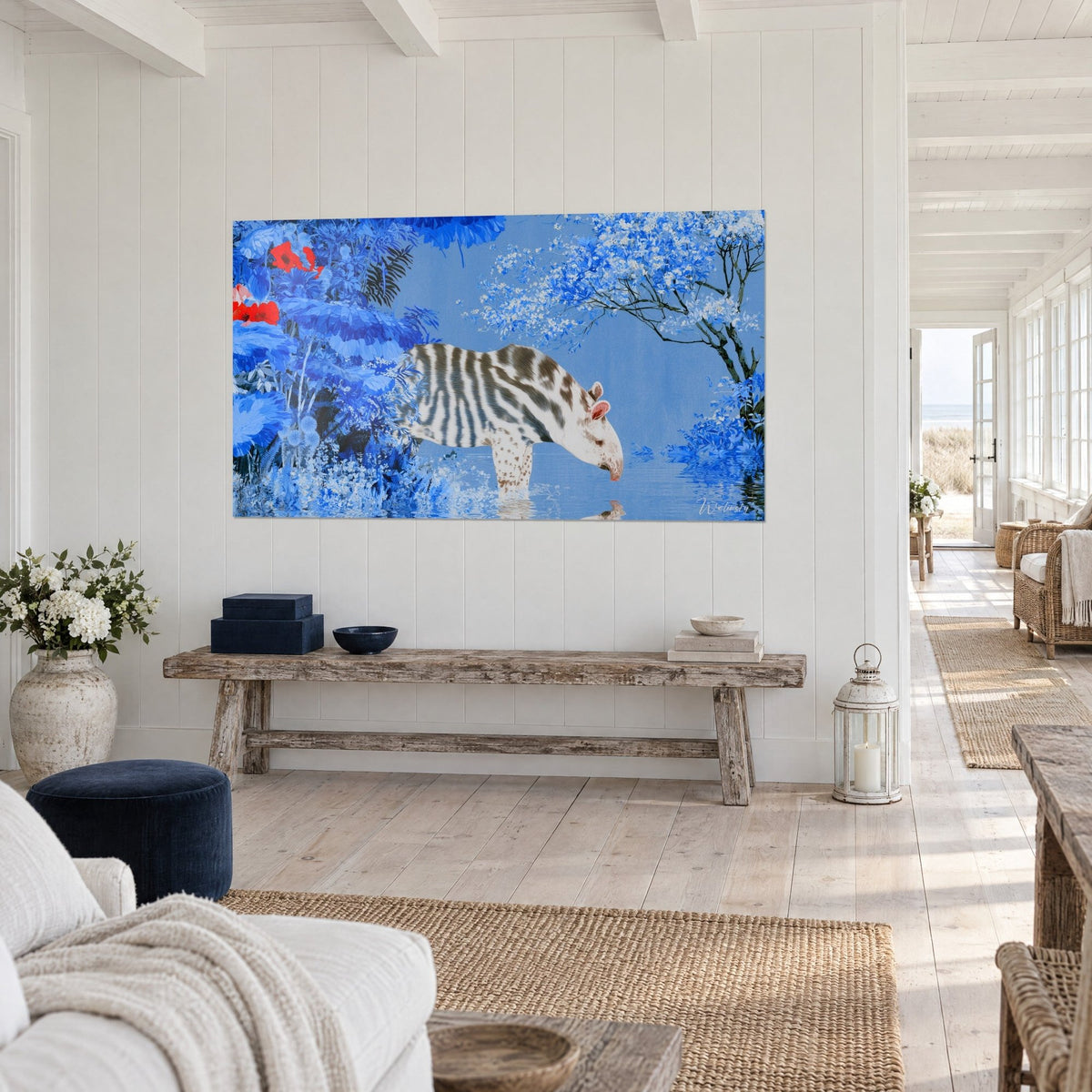 Wall art of a young striped tapir leaning over a pond, cobalt blue foliage and red flowers, on a white wall in three-quarter view