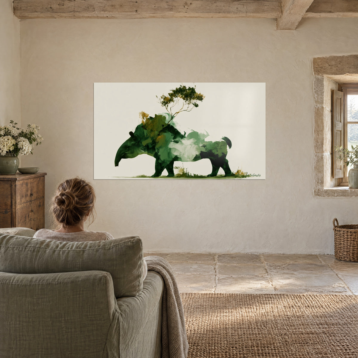 Tableau silhouette de tapir vert sauge et bouteille, arbuste doré sur le dos, jeune femme de dos dans un fauteuil, mur chaulé, fenêtre en pierre