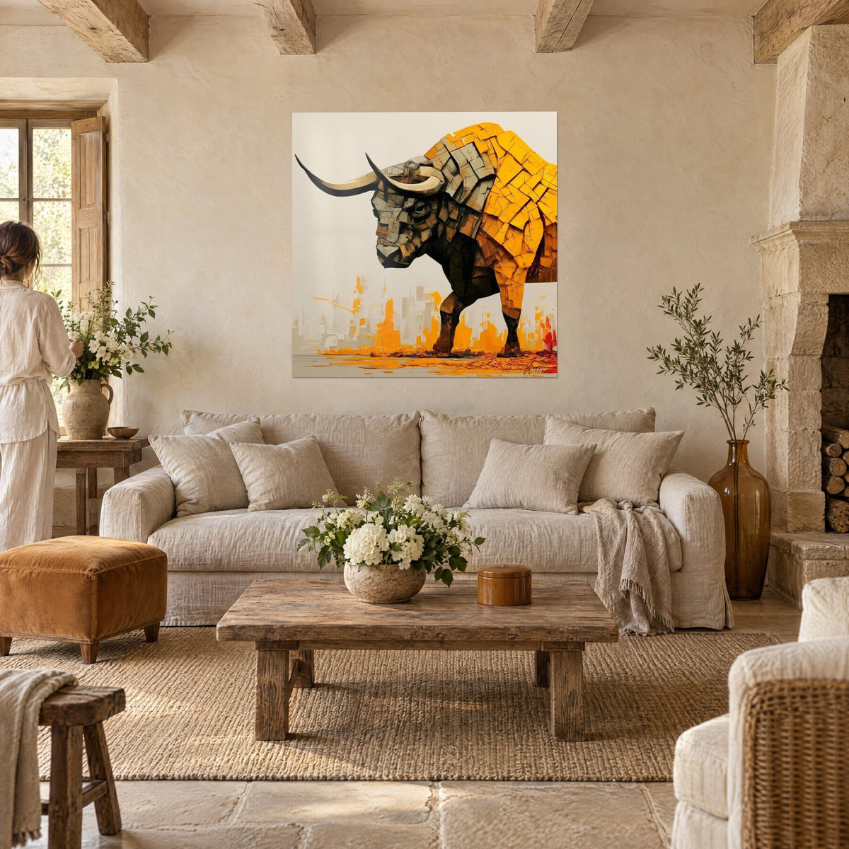 Quadro di un toro dorato dalle lunghe corna nere, groppa in schegge ocra su fondo crema, due persone di spalle sopra un divano in un soggiorno luminoso