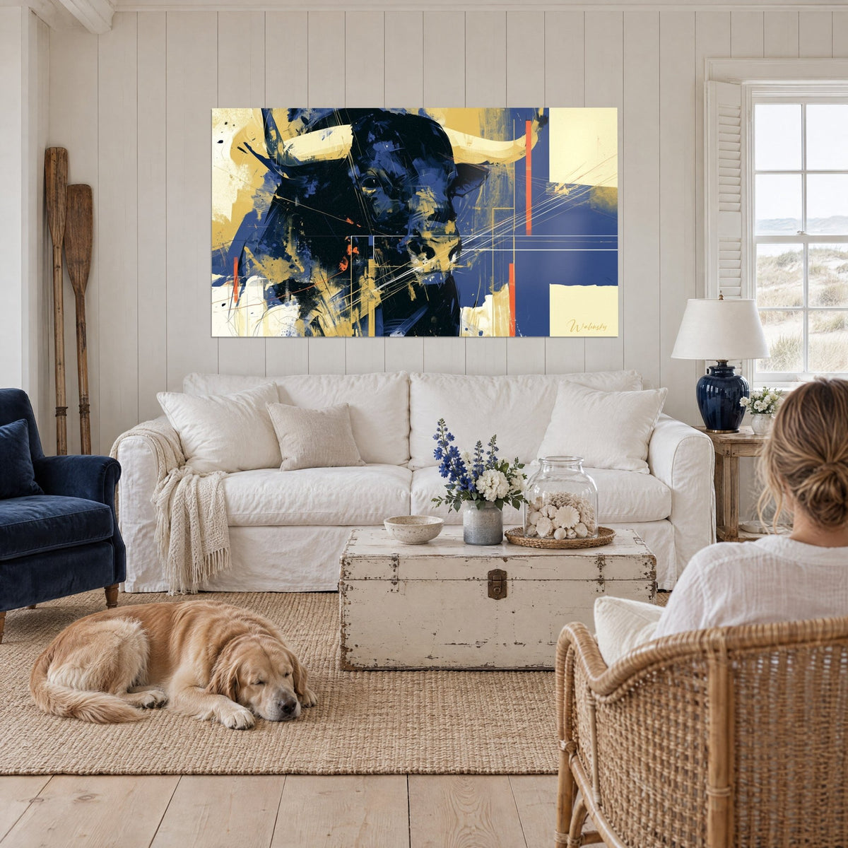 Quadro di un toro massiccio blu notte con corna color crema, riflessi dorati e tratti arancioni, sopra un divano in un soggiorno luminoso
