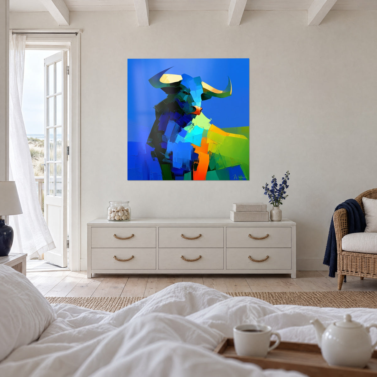 Cuadro criatura cornuda en facetas azul noche y turquesa, cuernos color crema, sobre una cama en un dormitorio claro