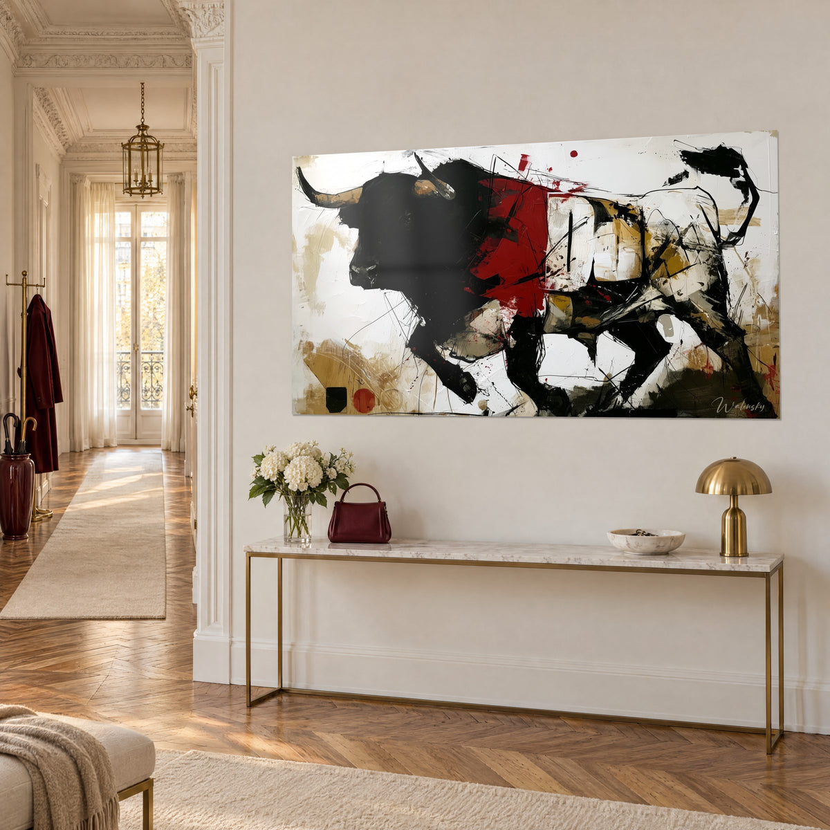 Cuadro de un toro corpulento en plena embestida, silueta de tinta negra, mancha roja intensa y trazos ocres, sobre una pared crema encima de una consola dorada