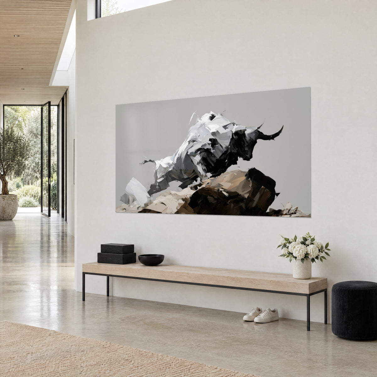 Wall art of a black and white bull leaping over a beige and brown rock, pearl grey background, three-quarter view in an architect-designed living room