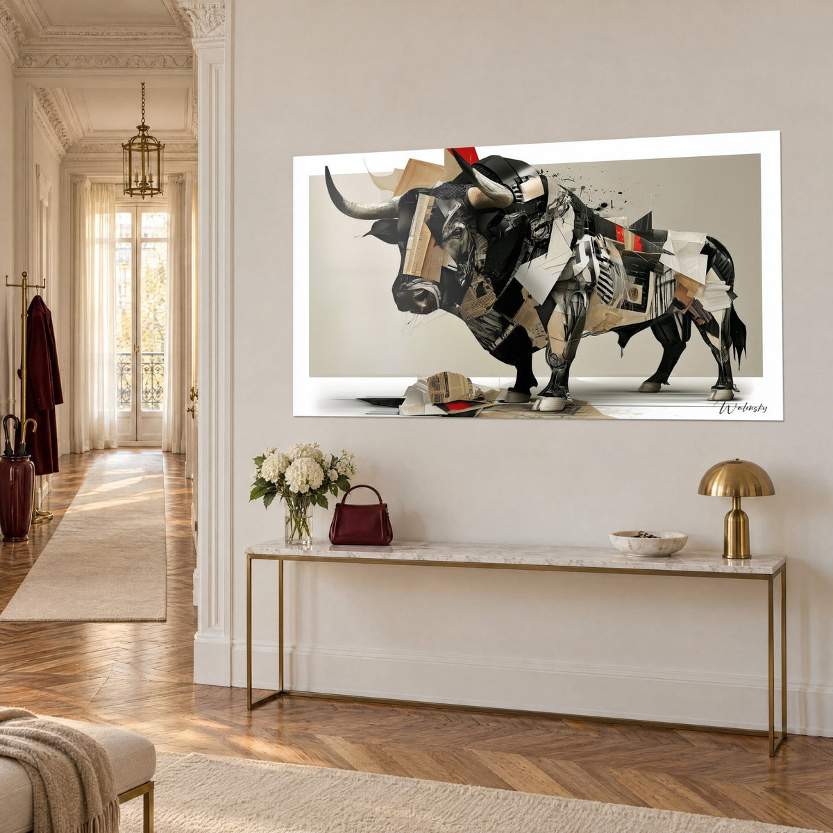 Quadro bovino frammentato in fogli di giornale beige e neri, bordo rosso vivo, appeso su una parete color crema sopra una consolle dorata