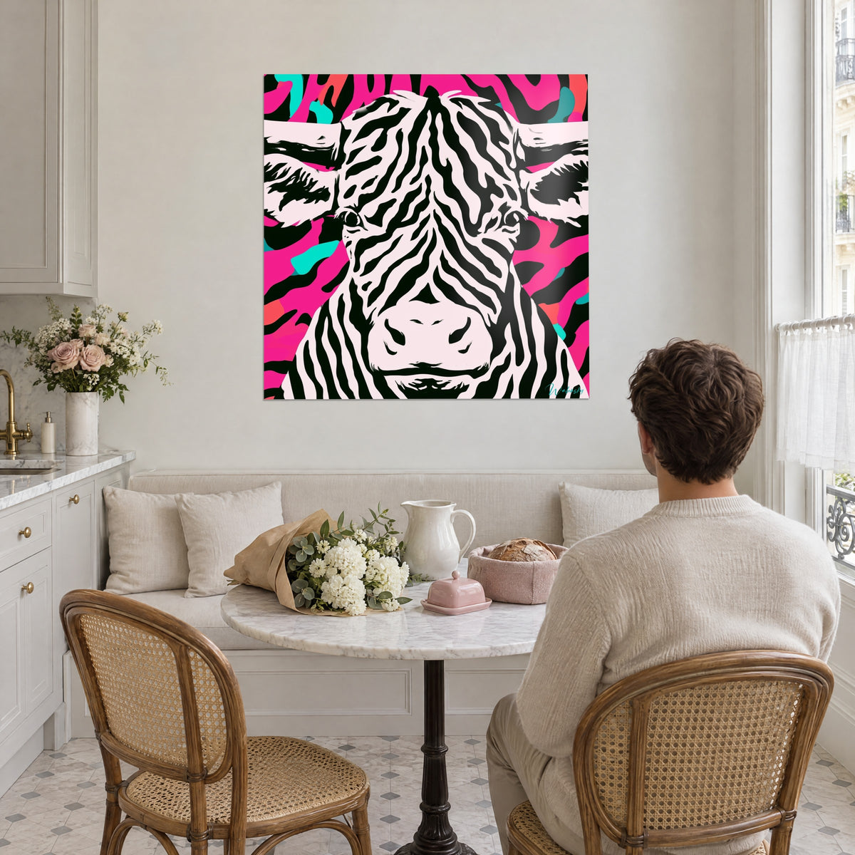 Cuadro retrato psicodélico de vaca, rayas negras sobre blanco rosáceo y fondo magenta, frente a una mesa de cocina