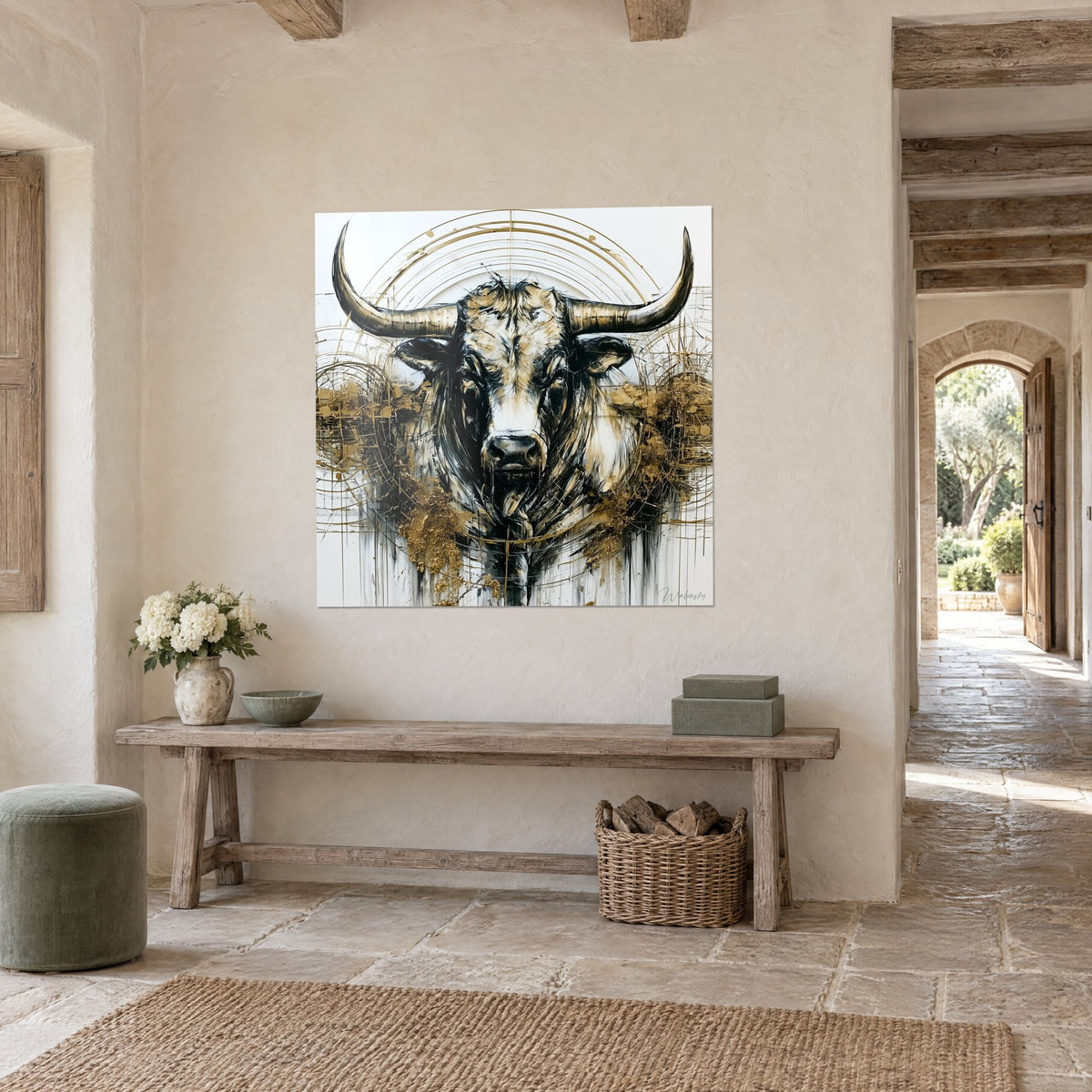 Quadro bufalo possente dalle lunghe corna nere, alone di cerchi dorati su fondo bianco, in un ingresso con pareti in pietra e travi