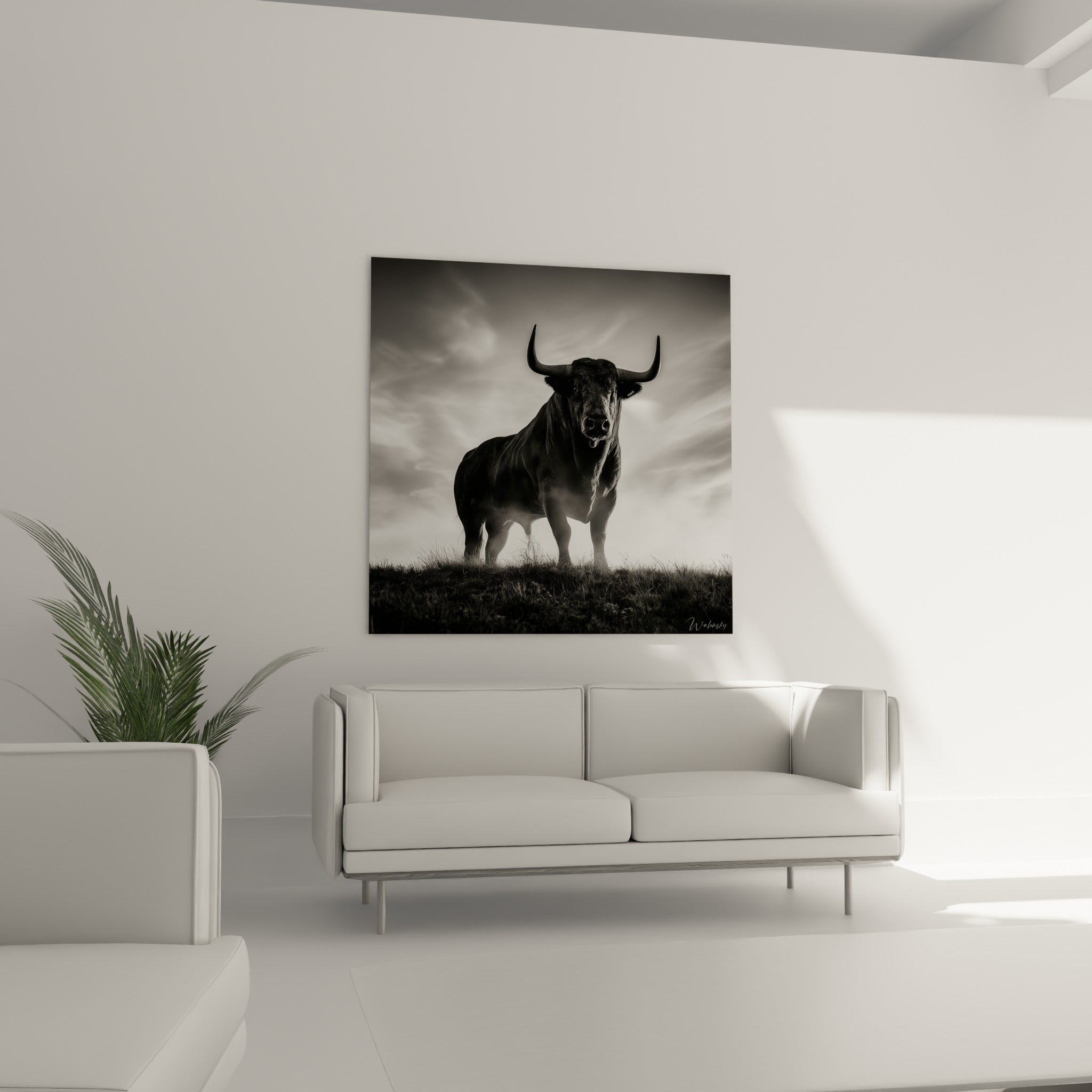 Cornes recourbées et regard sombre du taureau accrochés au-dessus d'un canapé dans un salon lumineux