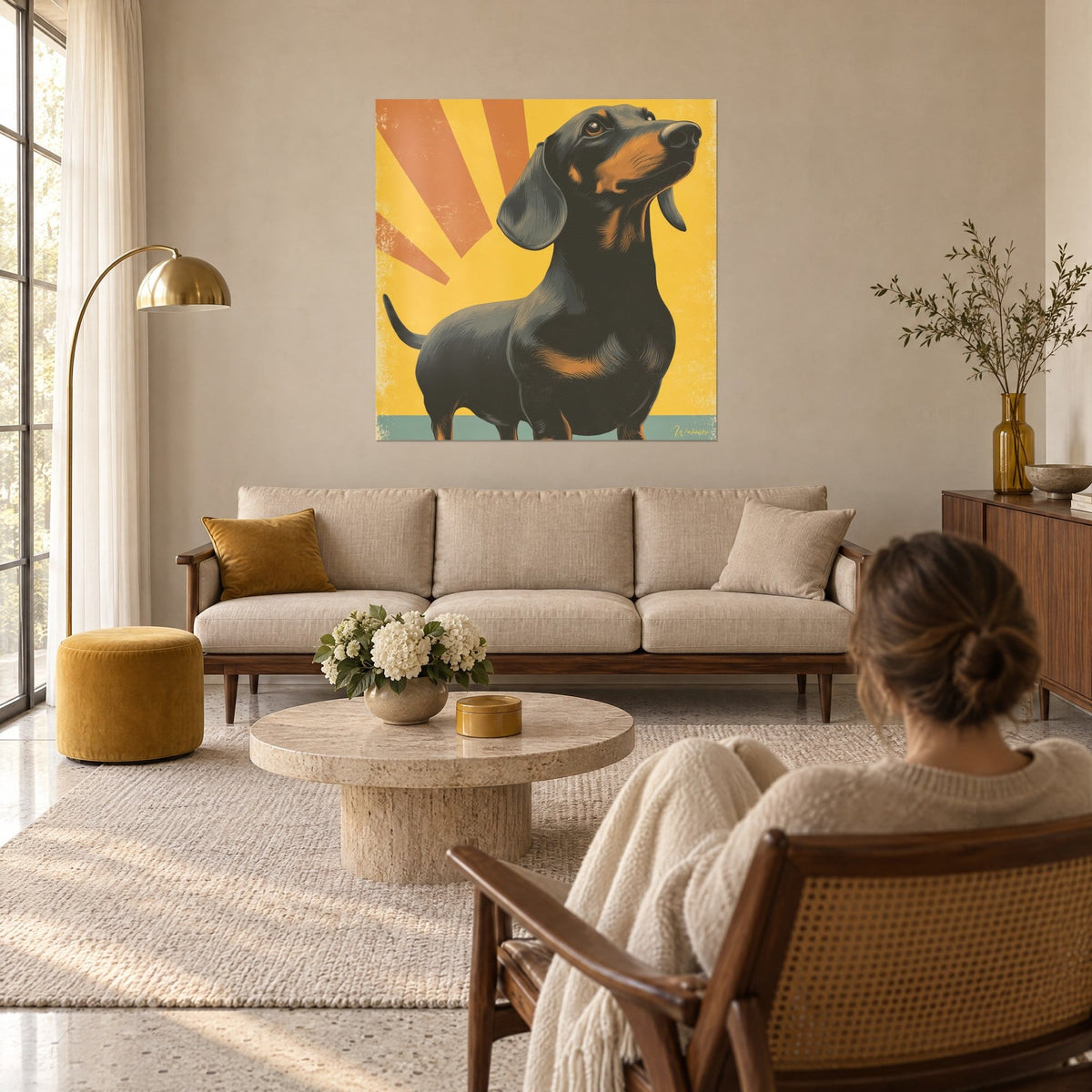 Gemälde Dackel schwarz und lohfarben, der die Schnauze zu orangefarbenen Sonnenstrahlen auf senfgelbem Grund hebt, über einem Sofa in einem hellen Wohnzimmer