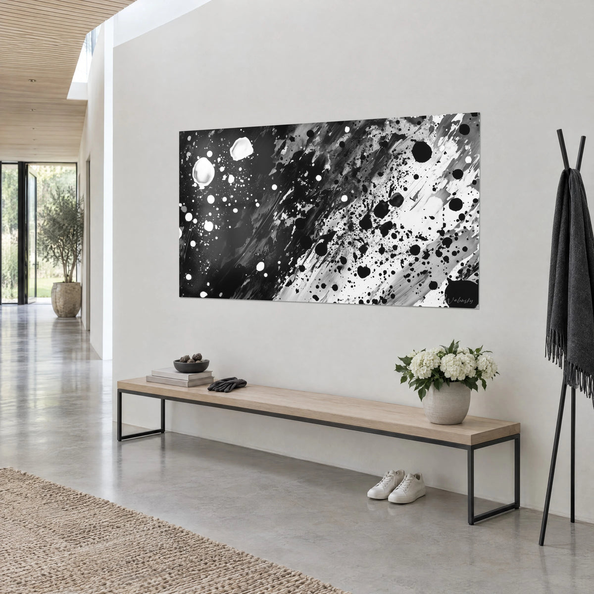 Tableau abstrait de taches d'encre noires jaillies sur un champ blanc strié de gris, vu de trois-quarts au-dessus d'un banc en bois
