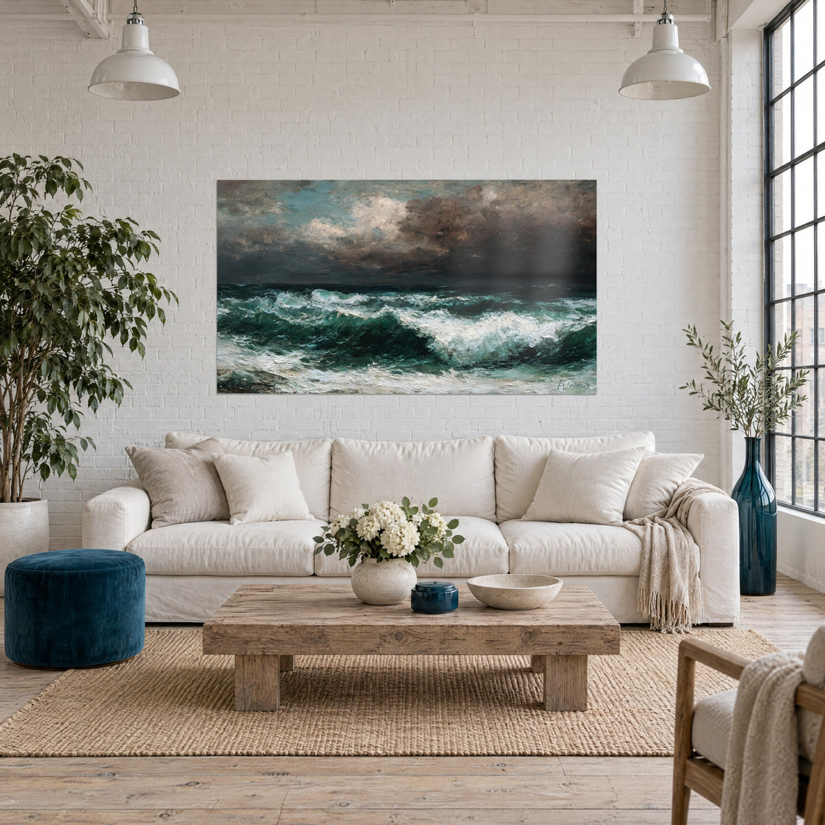 Wall art of a stormy sea with emerald green waves and white foam under brown clouds, above a sofa in a bright living room