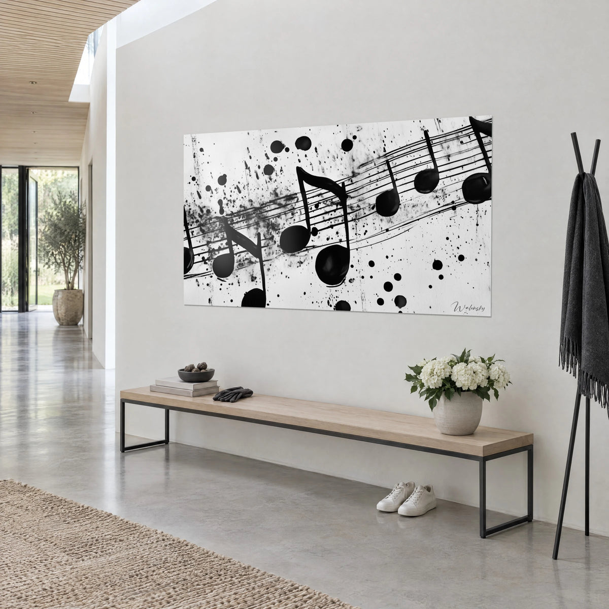 Wall art of giant black music notes on white paper, staves running diagonally, hung on the grey wall of a bright hallway