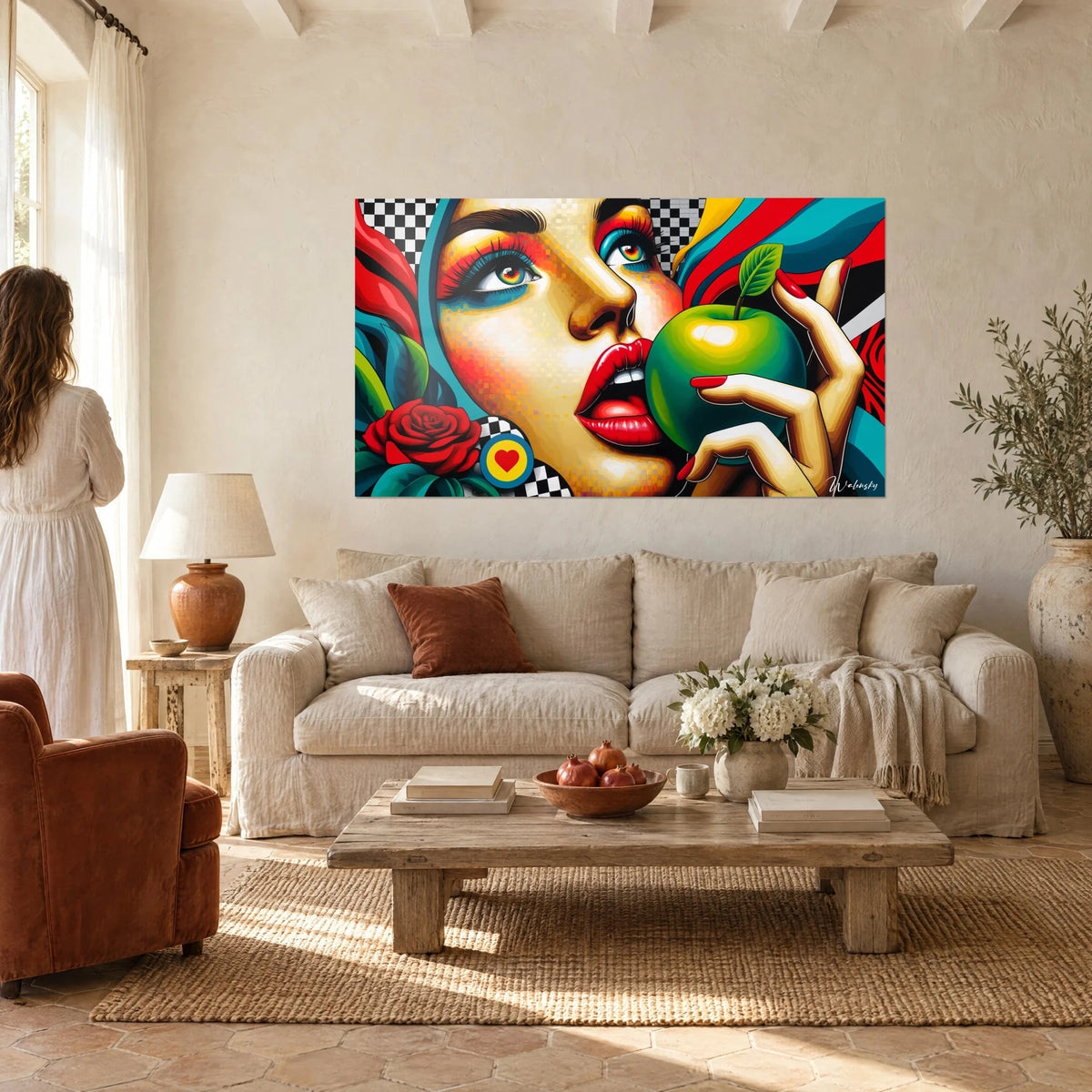Quadro volto pop art con labbra rosse che mordono una mela verde, sfondo a scacchiera in bianco e nero, sopra un divano in un soggiorno luminoso