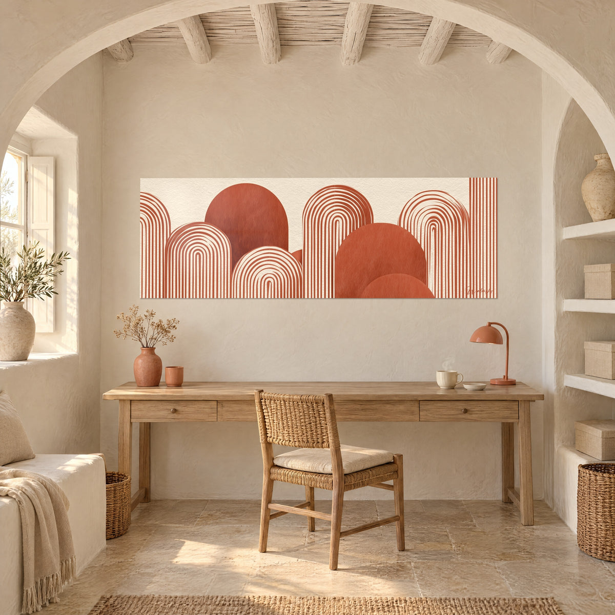 Tableau paysage géométrique d'arches rayées brique et ivoire, au-dessus d'un bureau en bois et d'une lampe orange