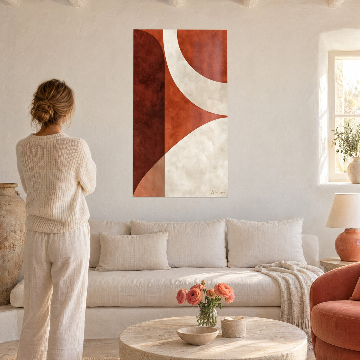 Wall art with intertwined brick and cream curves, marbled texture, a woman seen from behind looks at it above a sofa in a bright living room