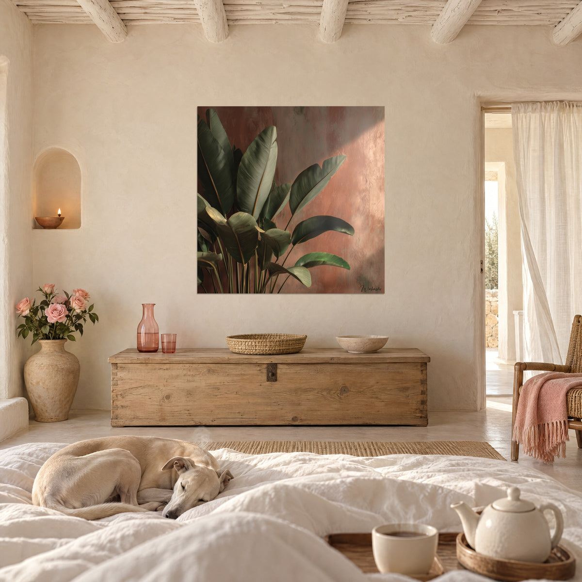 Tableau plante tropicale aux feuilles vert mousse et mur rose cuivré, au-dessus d'un lit dans une chambre claire avec un greyhound