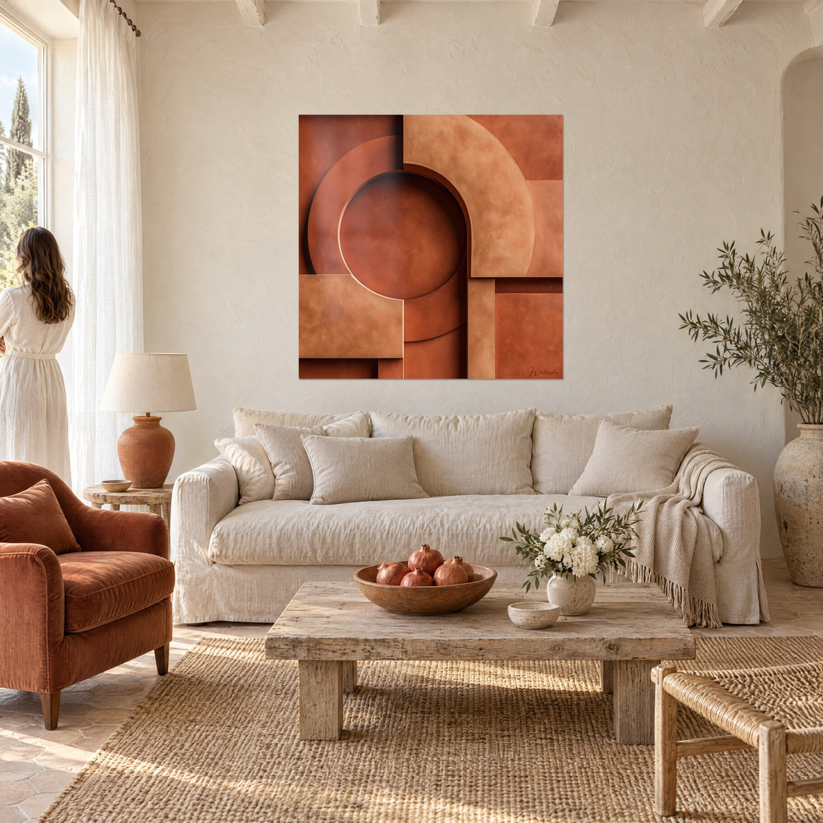 Cuadro arco geométrico en relieve, círculo color ladrillo y planos ocres, pareja de espaldas, sobre un sofá en un salón luminoso