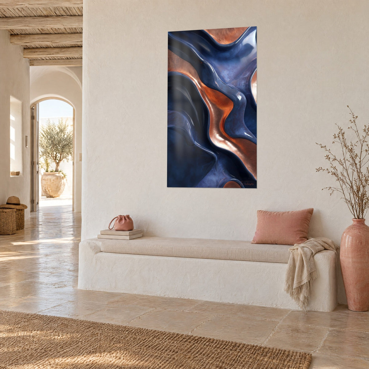 Cuadro ondulaciones metálicas índigo y cobre brillante, vista de tres cuartos sobre una pared blanca, banco de yeso y cojín rosa